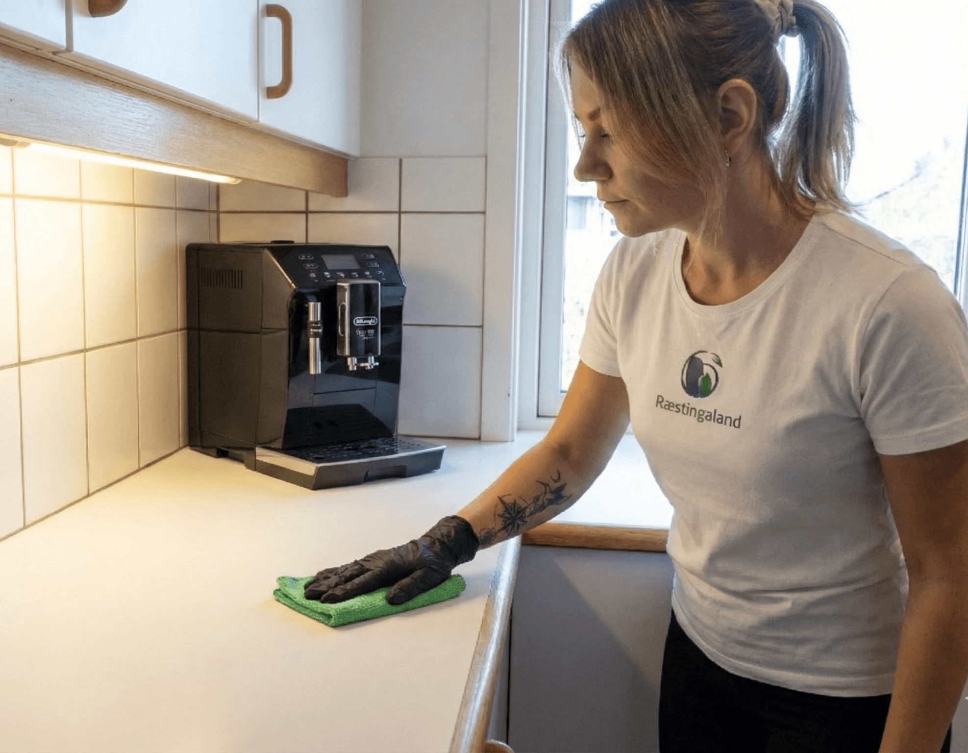 Starfsmaður Ræstingaland að þrífa skrifborð á skrifstofu.