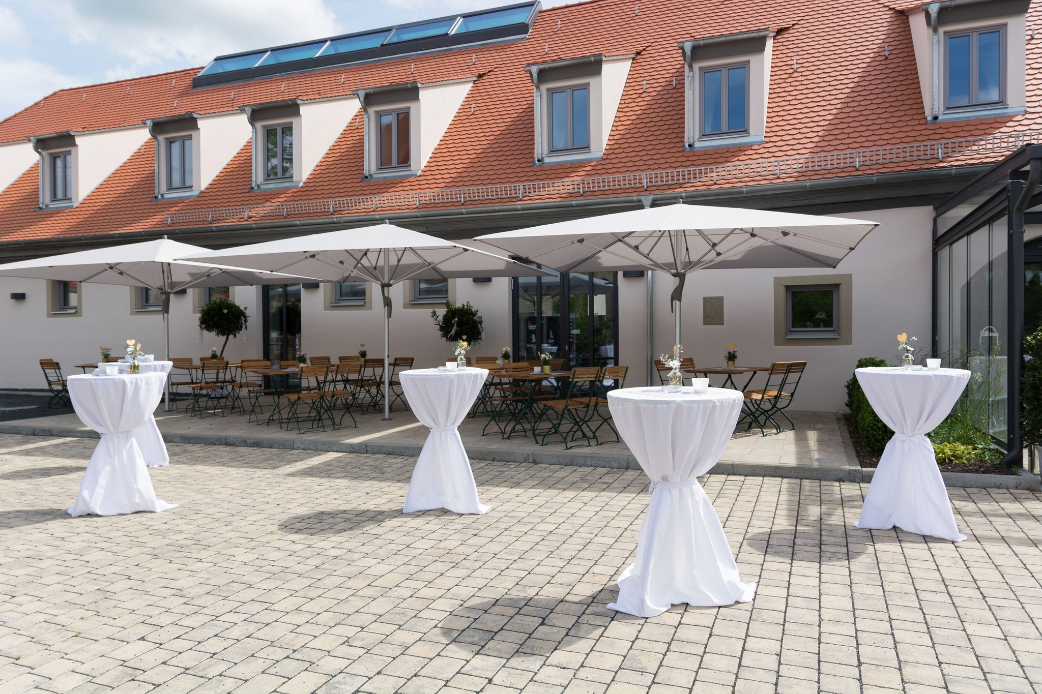 Außenbereich und Terrasse des Schafhofs Wiesentheid, ideal für den Sektempfang unter Sonnenschirmen.