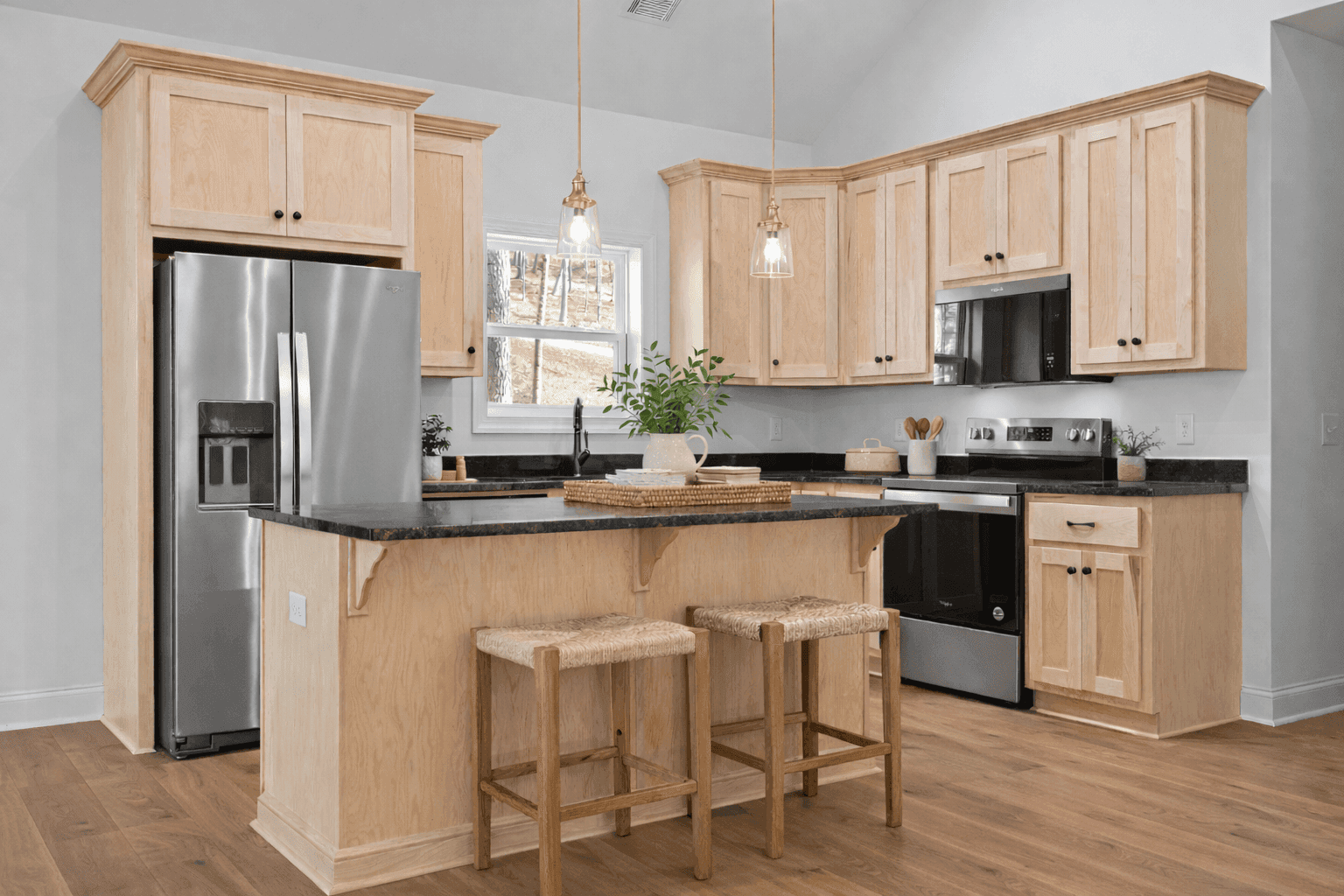 Open concept kitchen and living room with vaulted ceilings and hardwood floors