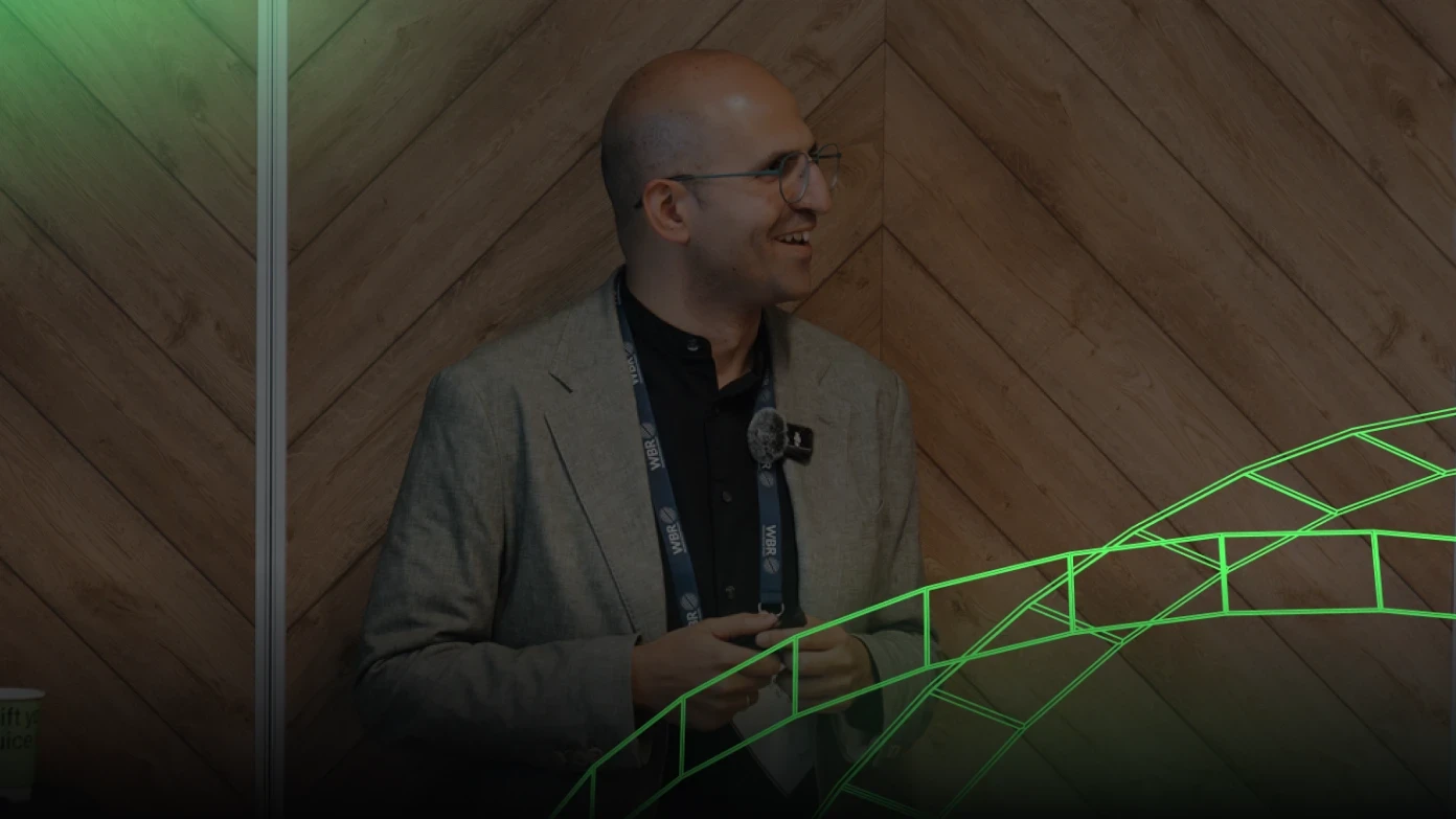 Speaker on stage with green graphic overlay