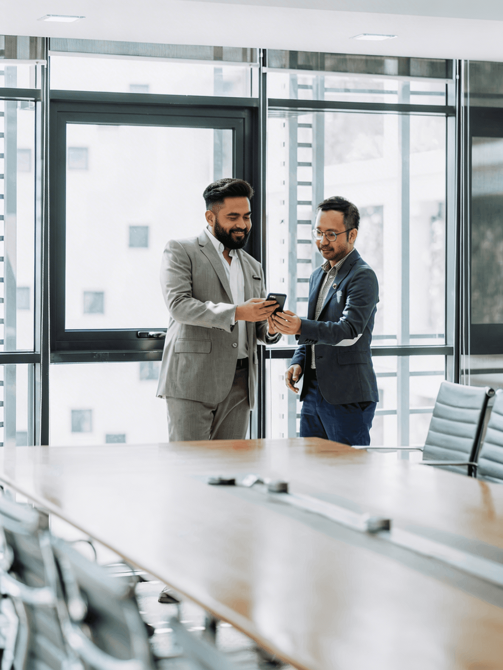 two men shaking hands in a conference room