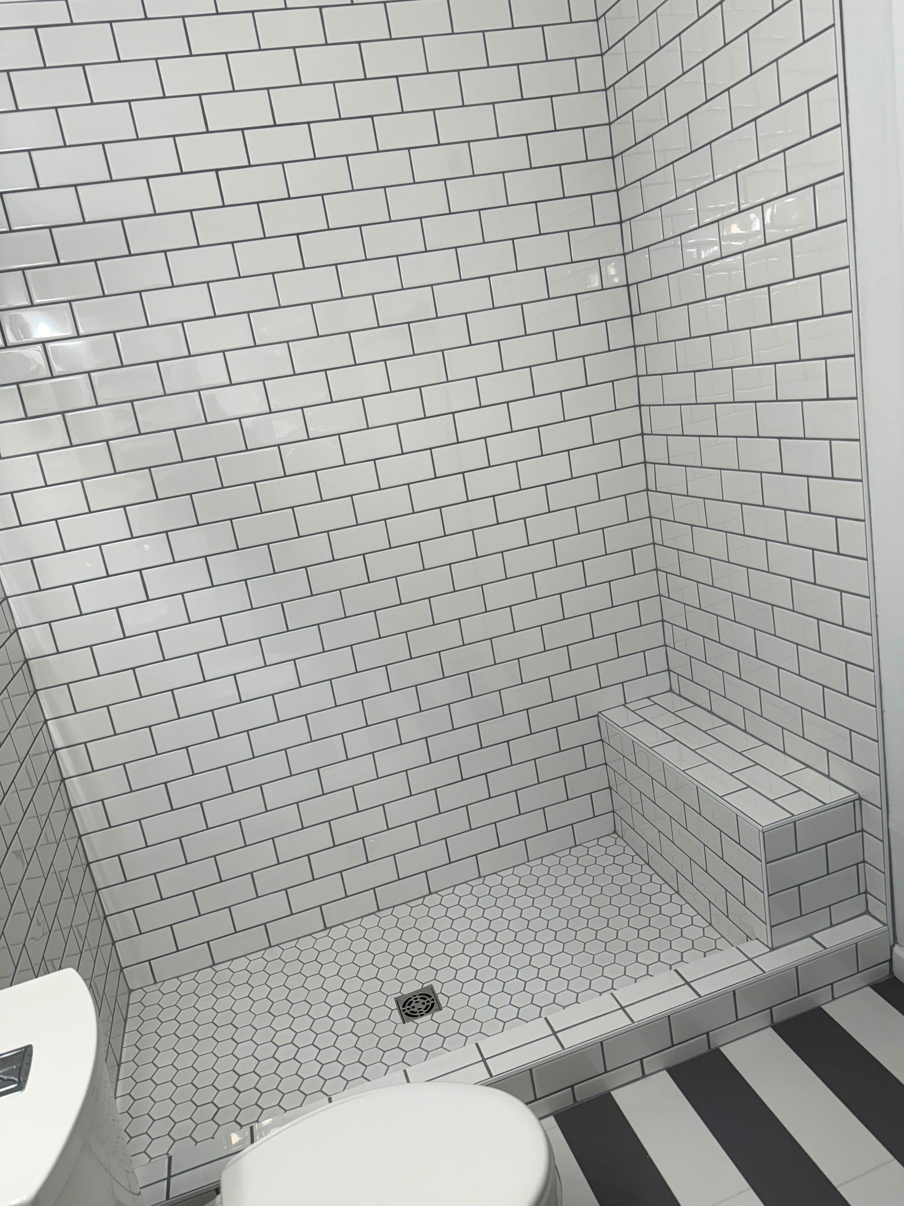 Luxurious bathroom vanity area with a dramatic wall featuring large format natural stone tiles in varying earthy tones and complex veining, serving as a striking backsplash above a double sink vanity.