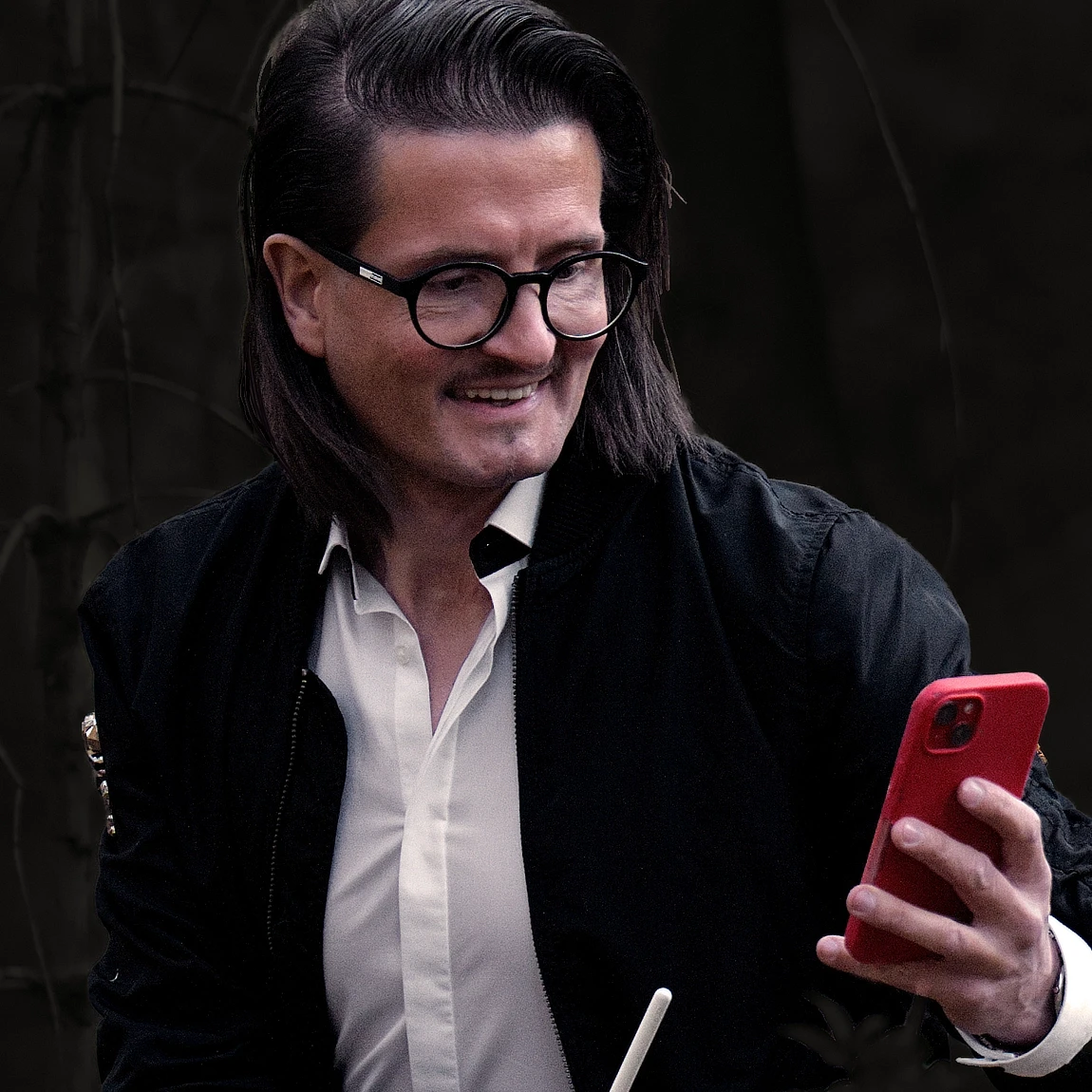 Lead Designer und Gründer prüft Inhalte auf einem mobilen Gerät und reflektiert Designentscheidungen.