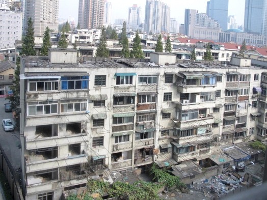 A photo o some old comunist looking apartment buildings and some new skyscrapers in the distance.