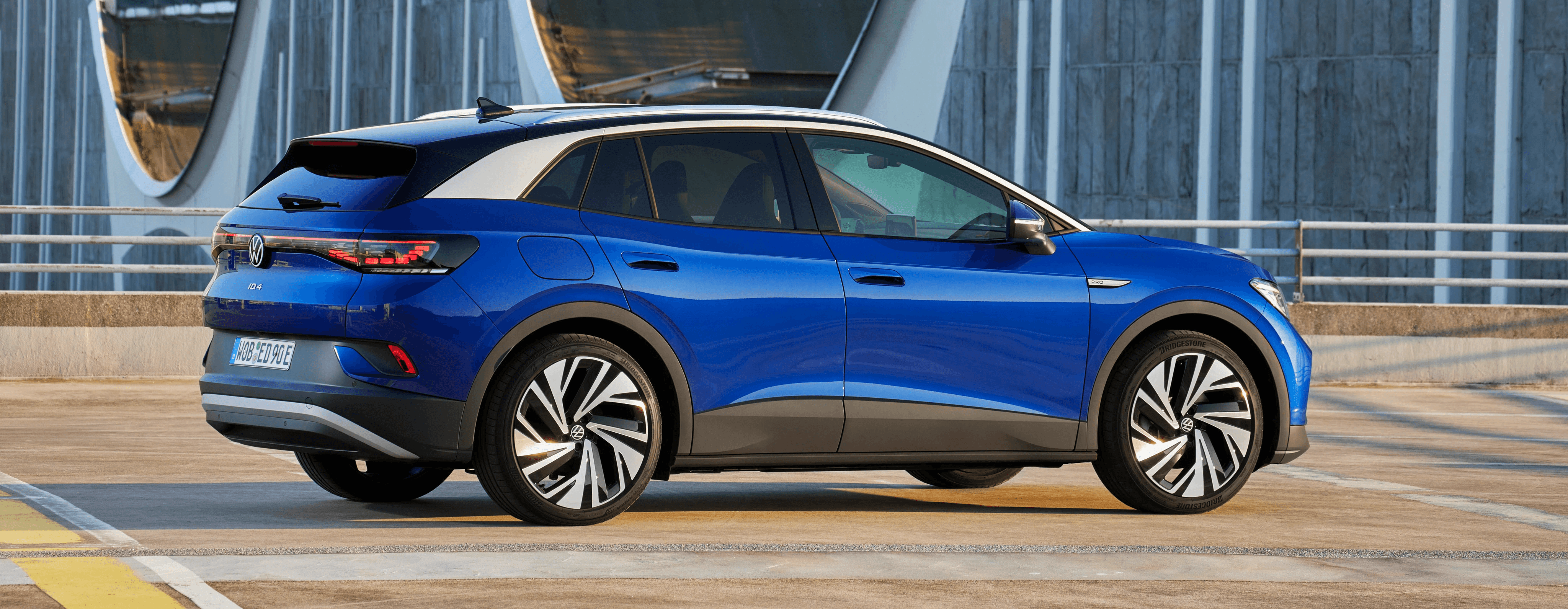 Volkswagen ID.4 bleue vue latérale dans un environnement urbain moderne, SUV électrique au design épuré