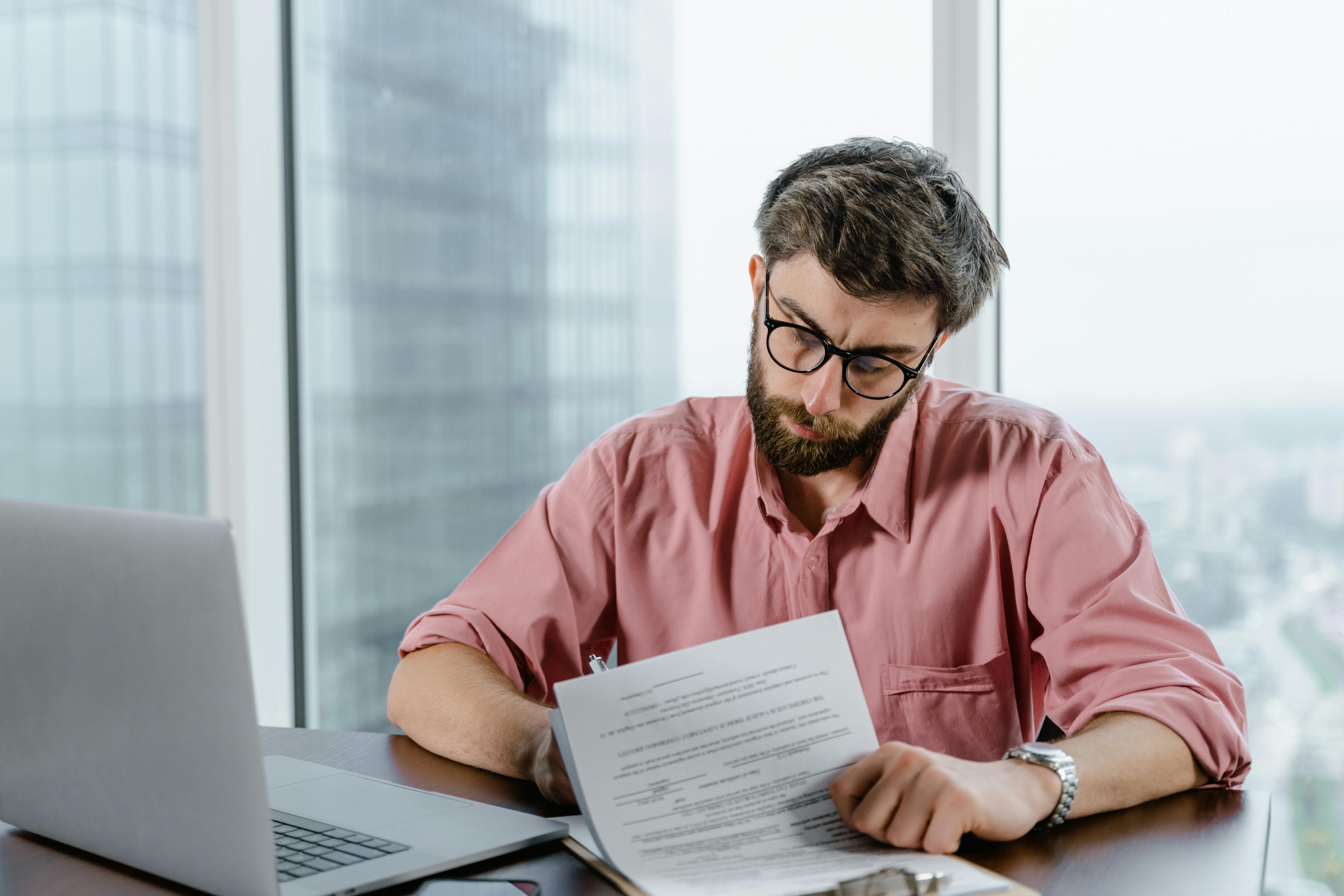 Consulente revisiona documento al laptop in ufficio: pianificazione e strategia