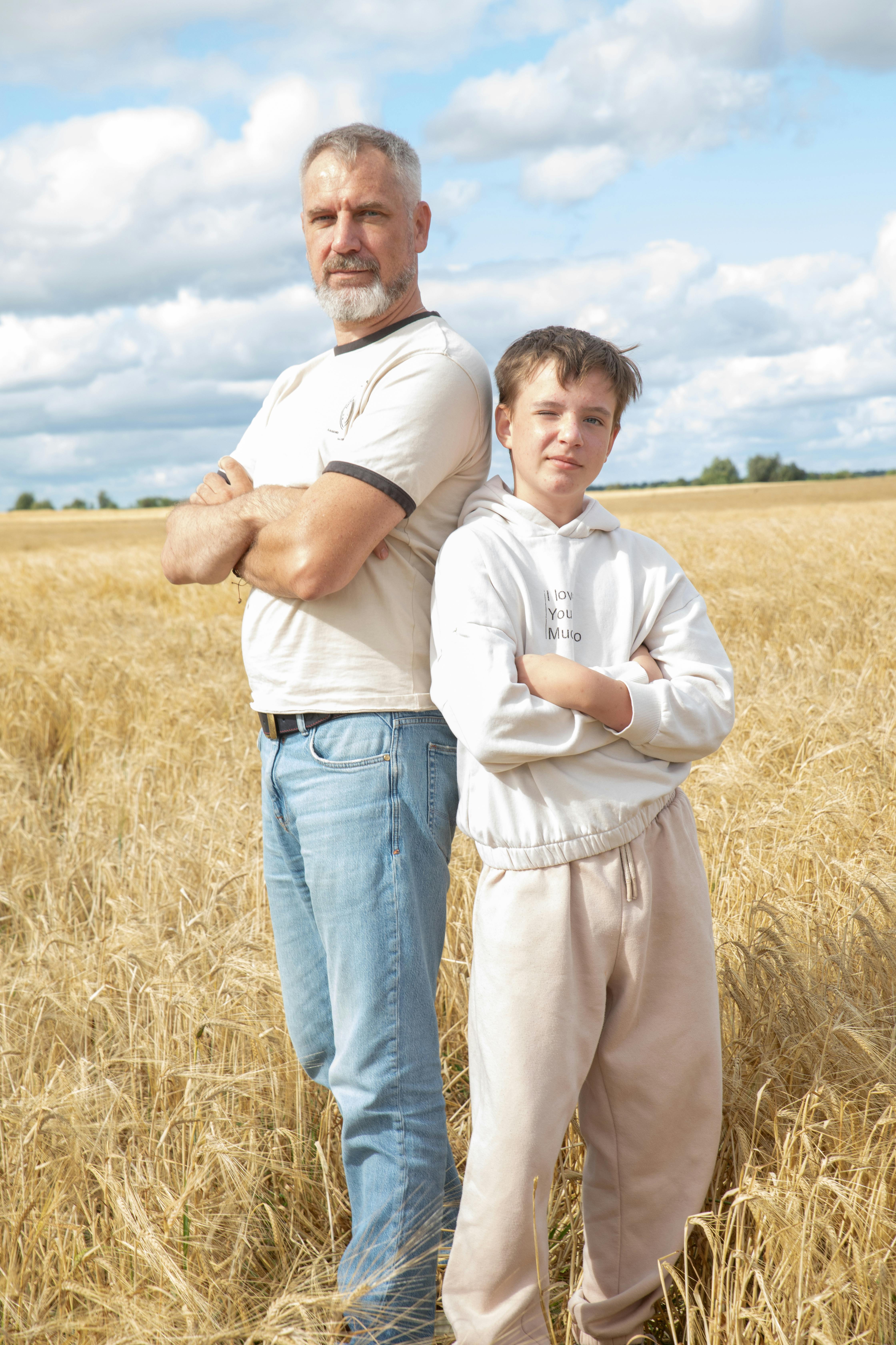 Conversion Truth for Families - Father and teen son standing side by side with arms crossed outdoors