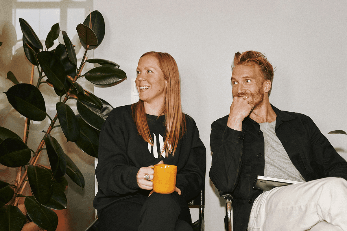 Zandra Friman and Emil Tiismann sitting on chairs and laughing