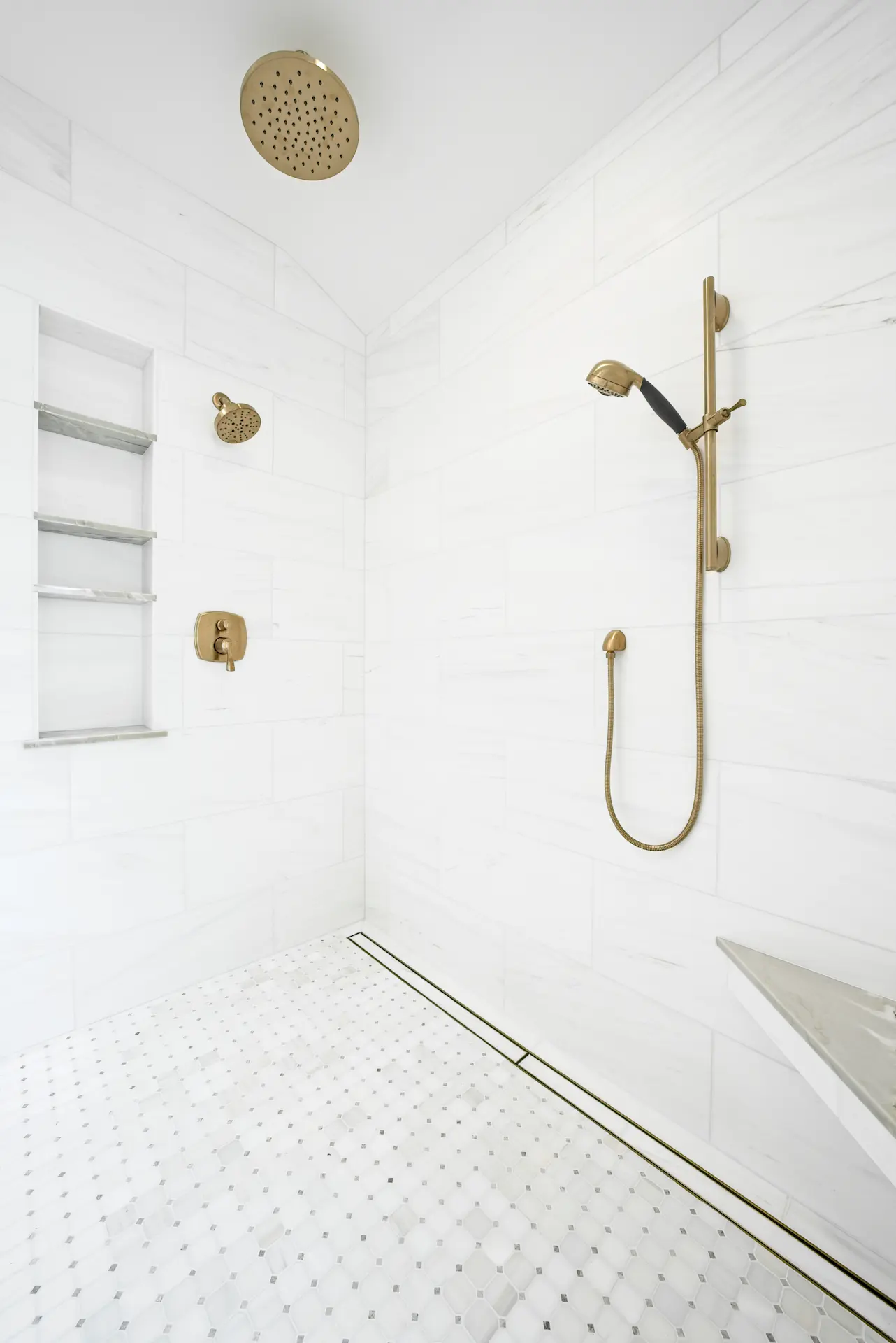 Angled portrait in the primary bathroom focusing on the shower fixtures, showcasing the attention to detail and premium materials used in the Dana Point Full Remodel. Photo by Todd Huge.