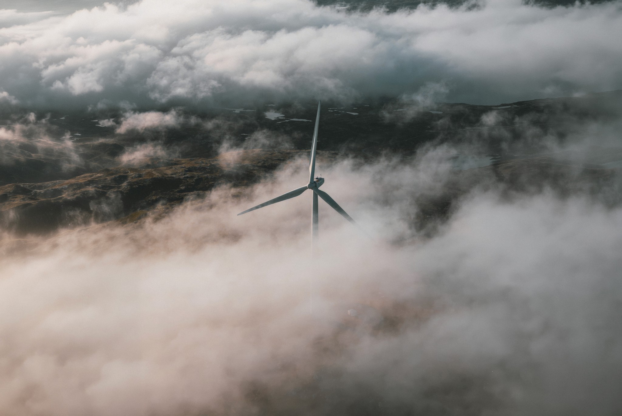 Dronefoto av vindburbin i skylagt fjellandskap