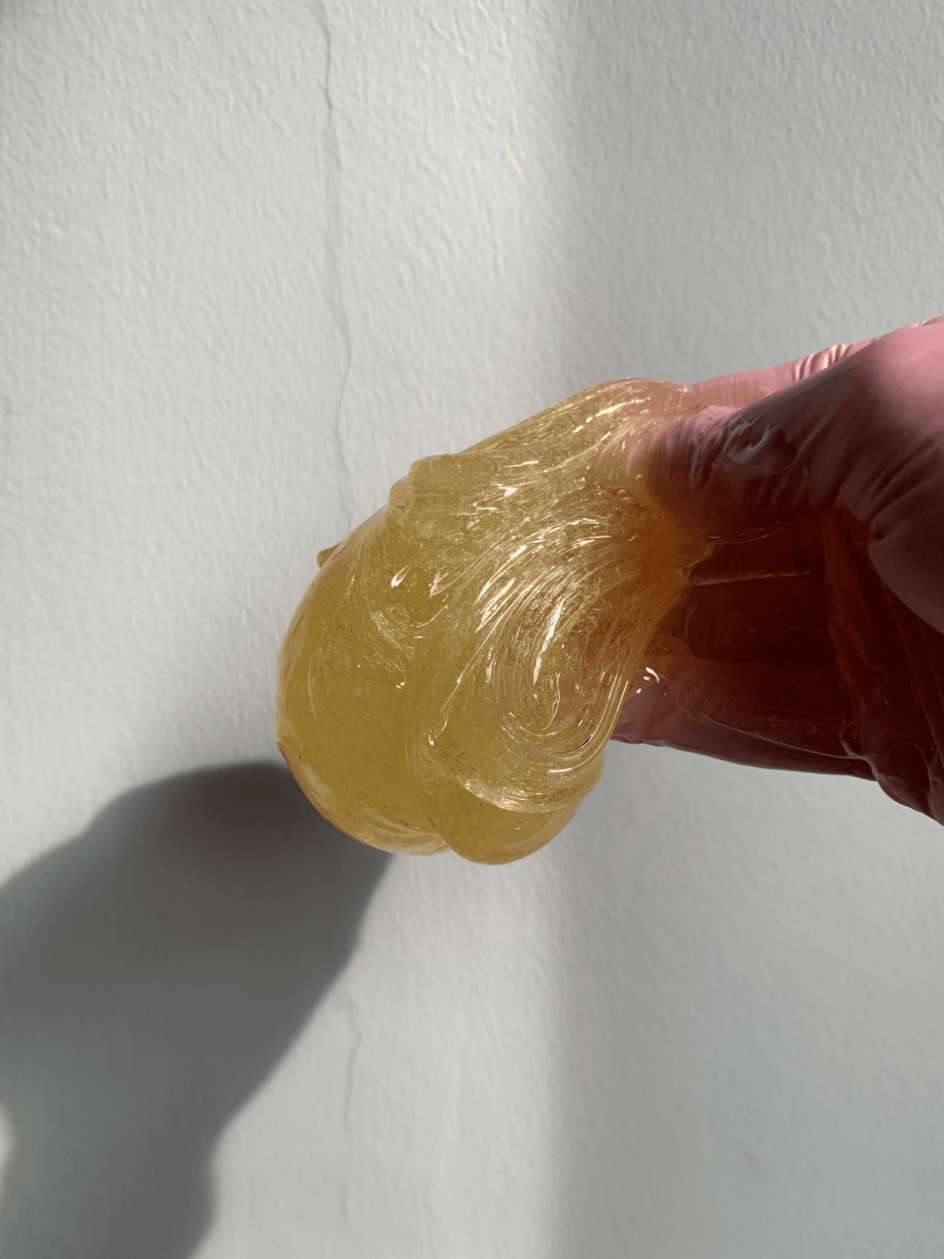 Gloved hands holding sugar paste used for hair removal