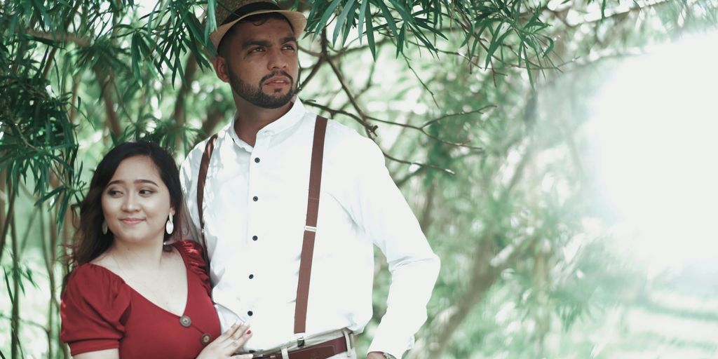 a man standing next to a woman under a tree