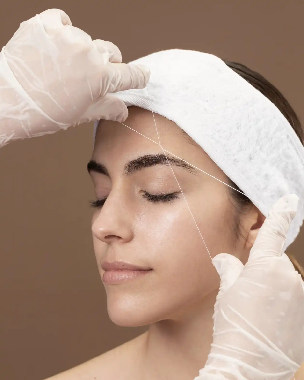 A modern black speaker illuminated by soft light, set against a green background.