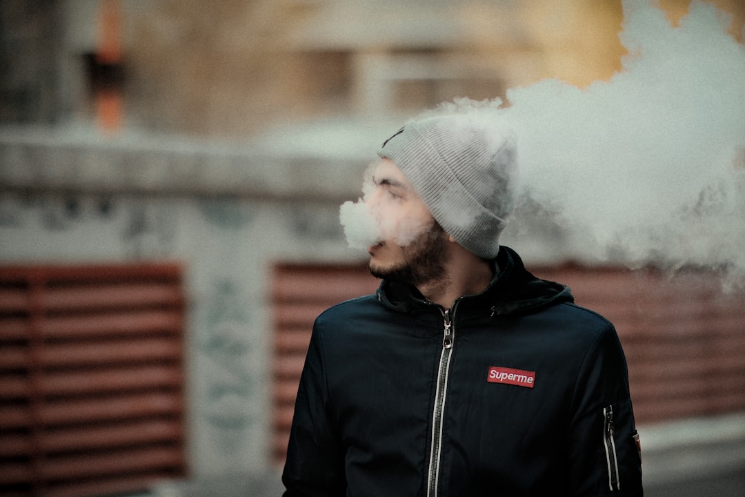 a man wearing a beanie smoking a cigarette