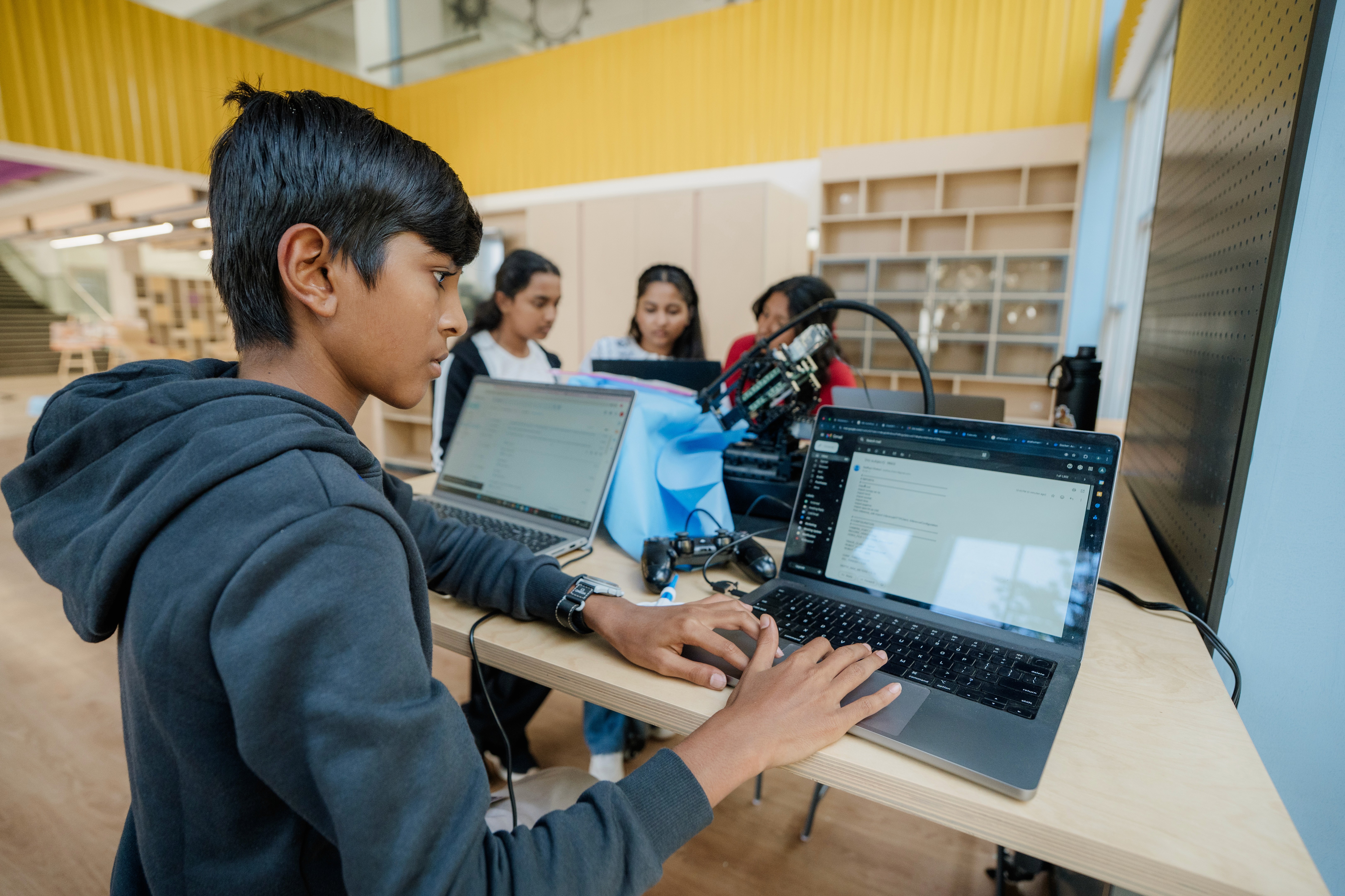Student coding with laptop during robotics class