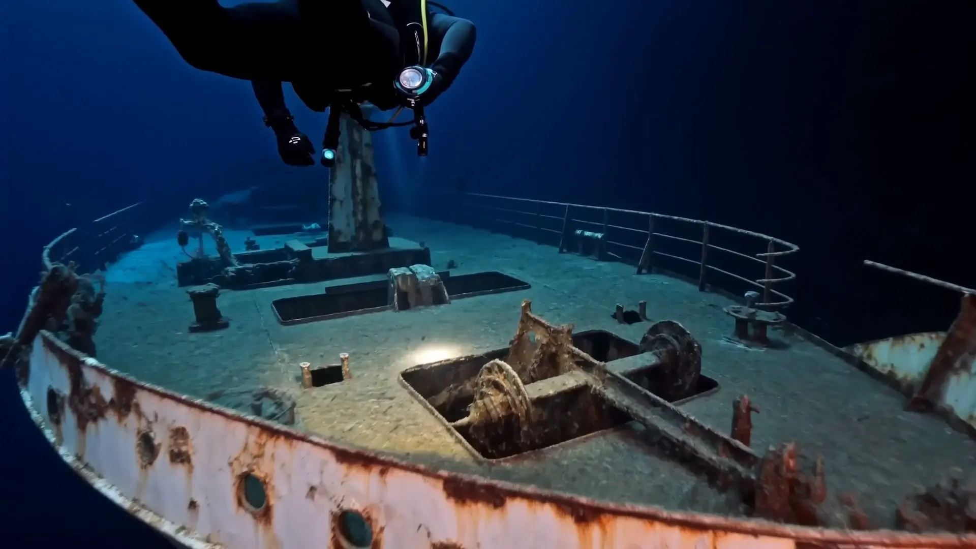 Diver's light sweeping across a wreck deck