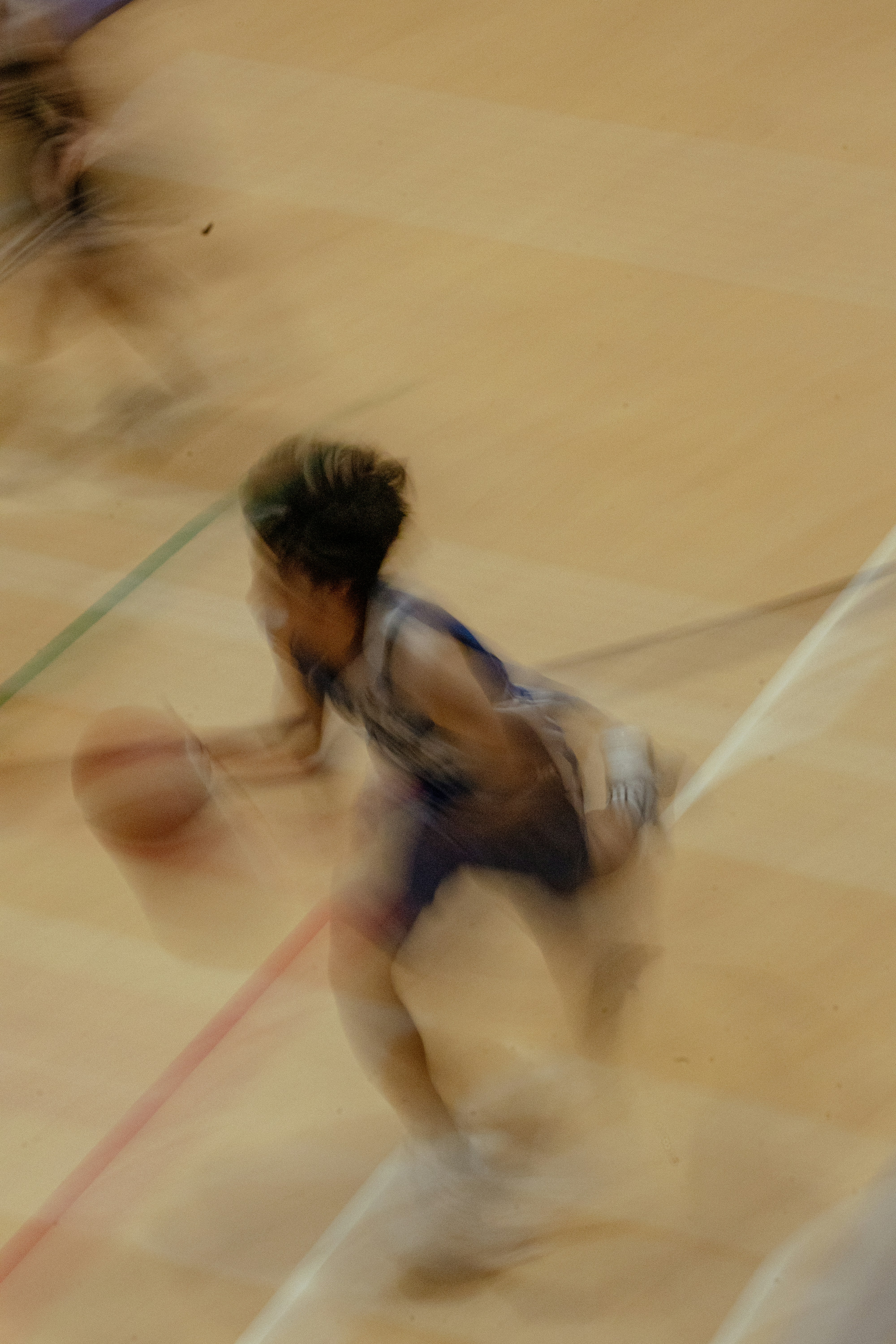 Blurry basketball player dribbling on court