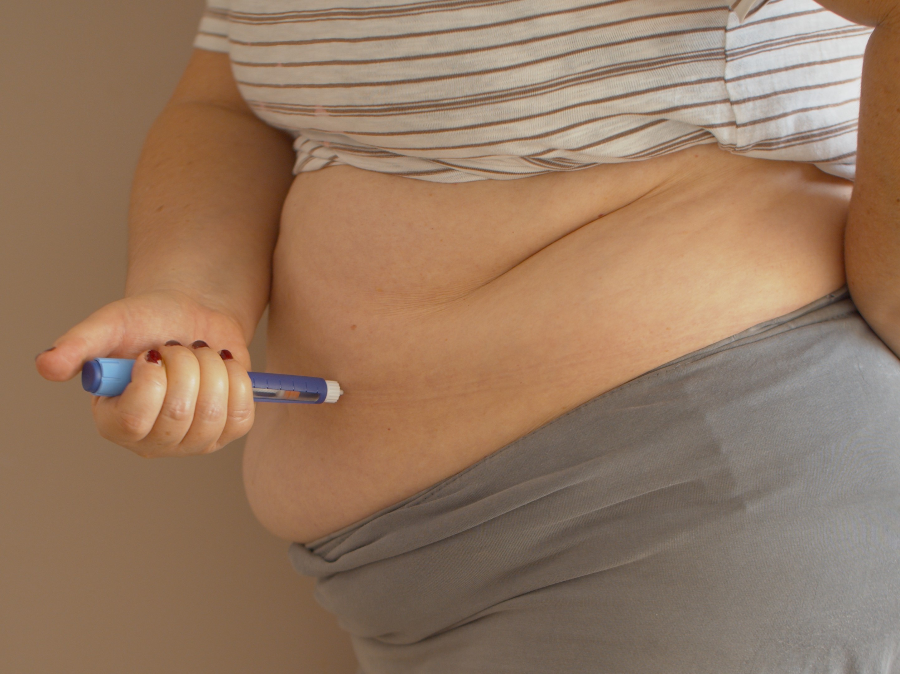 overweight woman injecting her diabetes medicine for weight loss into her stomach