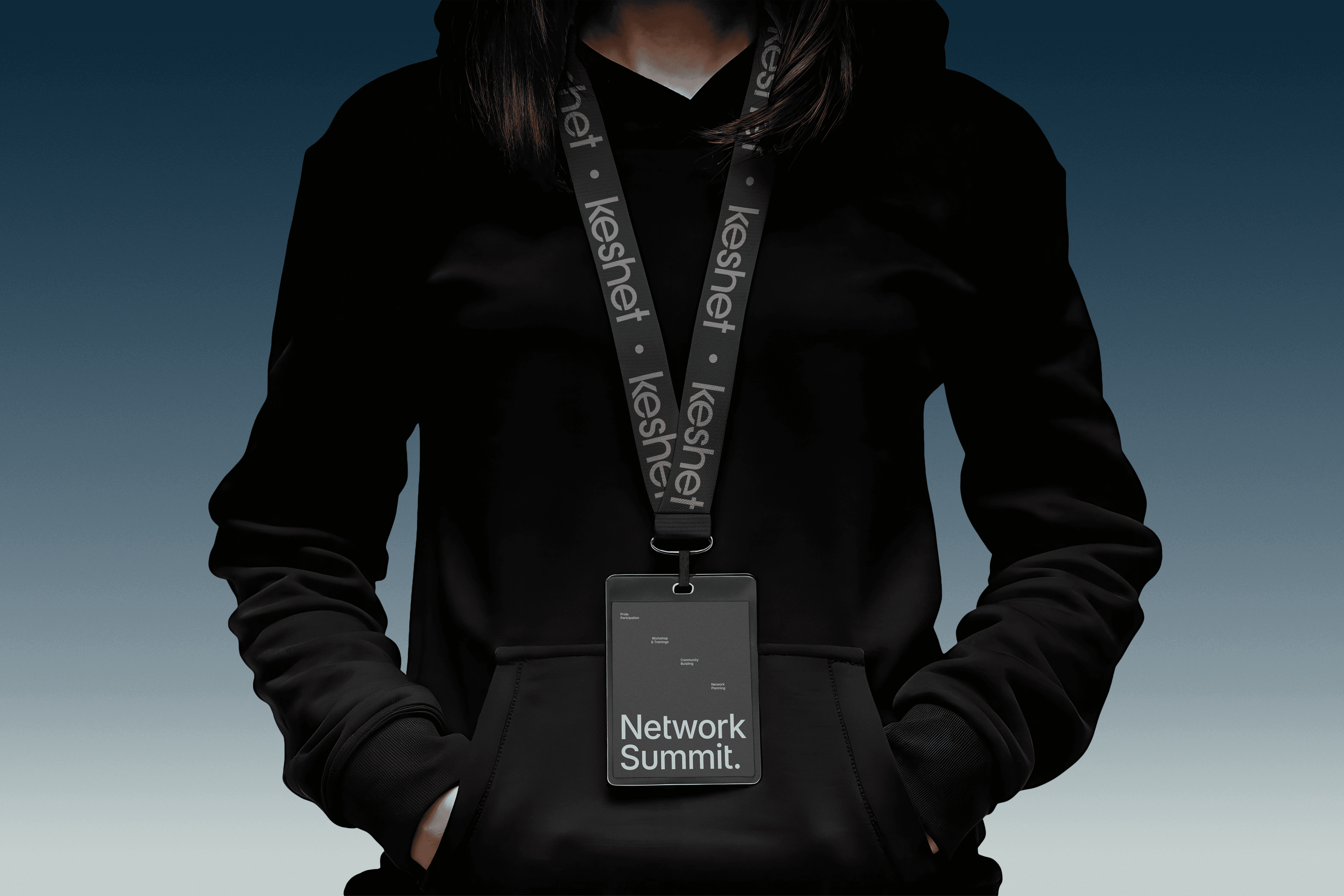 A person wearing a black hoodie and a Keshet branded lanyard with a "Network Summit" identification badge.