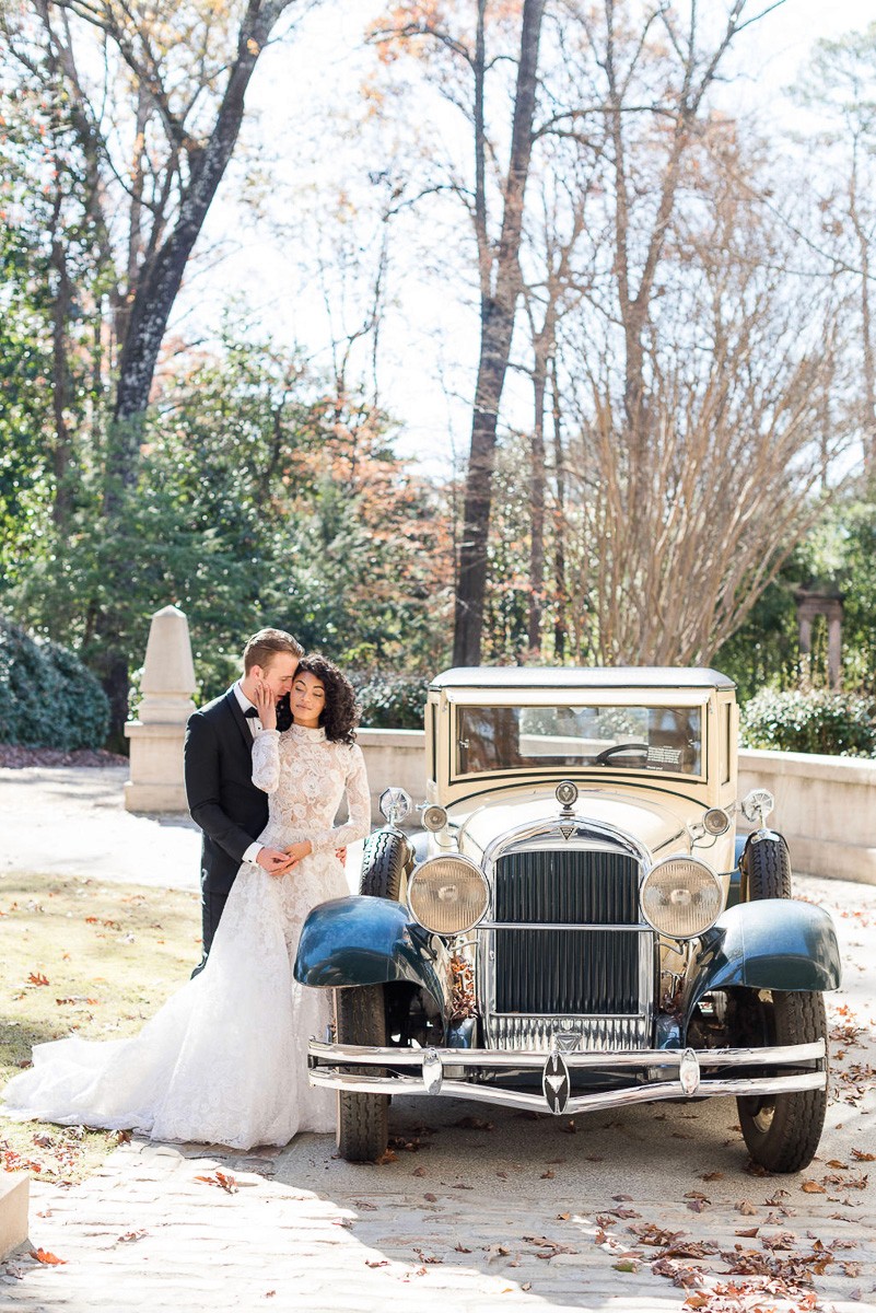 Wedding portrait of bride and groom with vintage car at swan house luxury wedding venue in Atlanta Georgia.