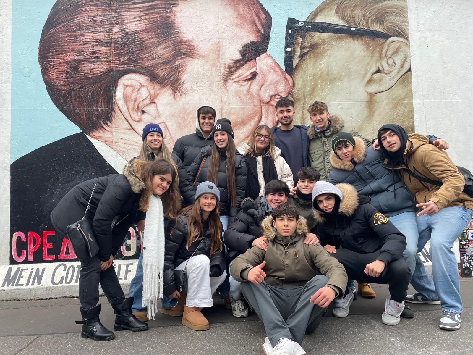 Close-up of lush, dark green leaves, some glossy and wet, against a muted background.