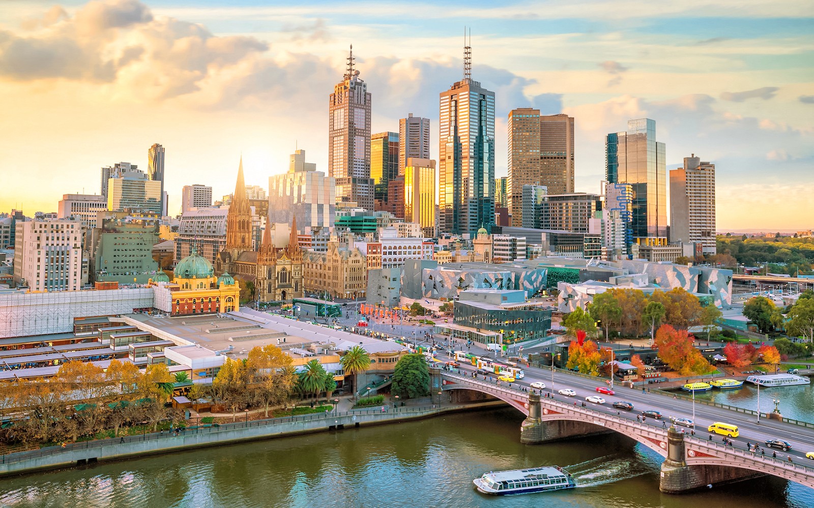 Melbourne skyline with Yarra River and city buildings at sunset.