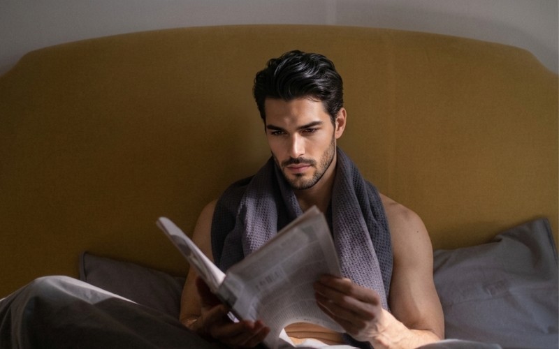 Person reading in bed during a structured morning routine at home&nbsp;