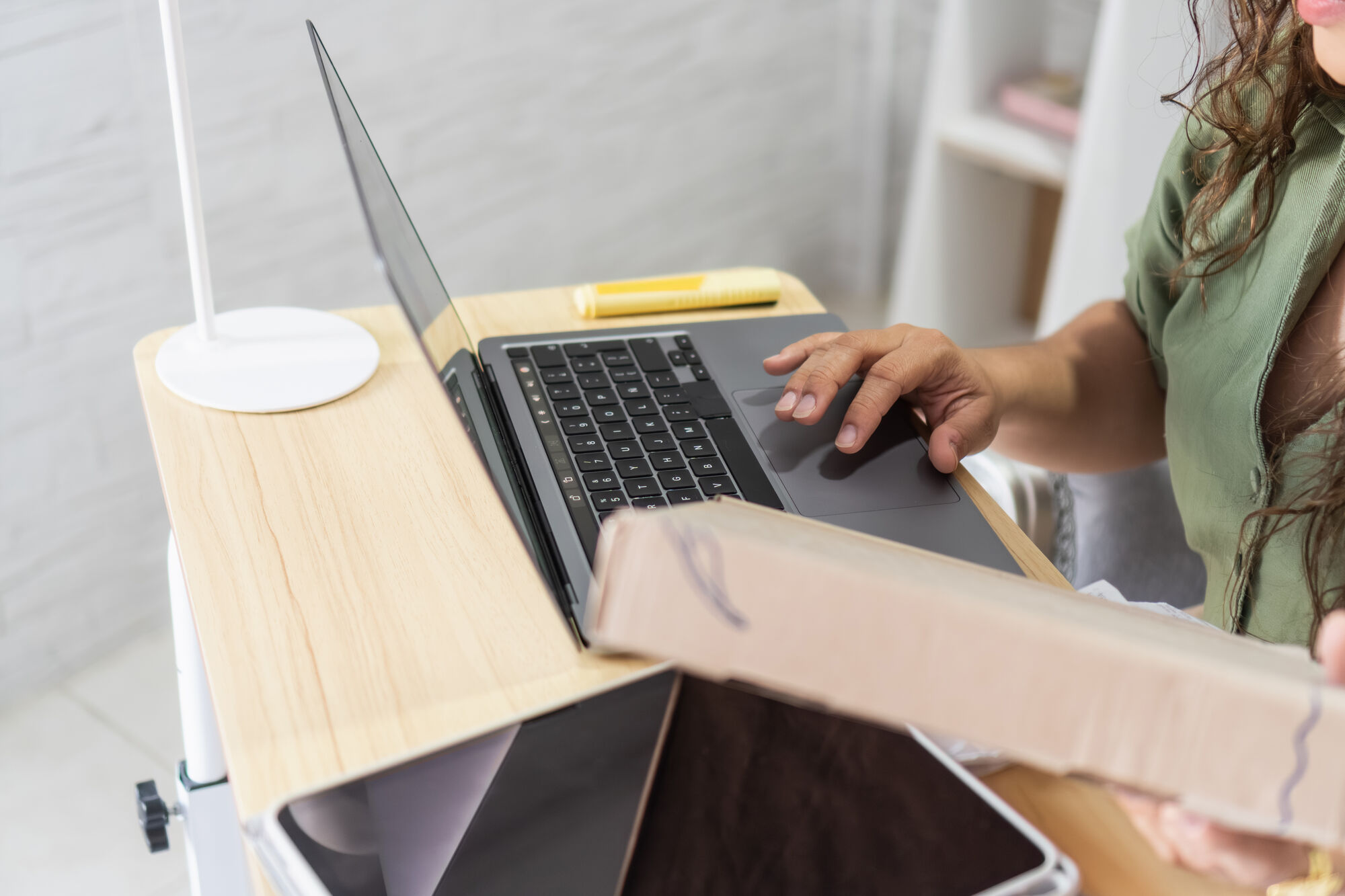 Silhouette of a researcher examining a slide under a microscope with a blue background.