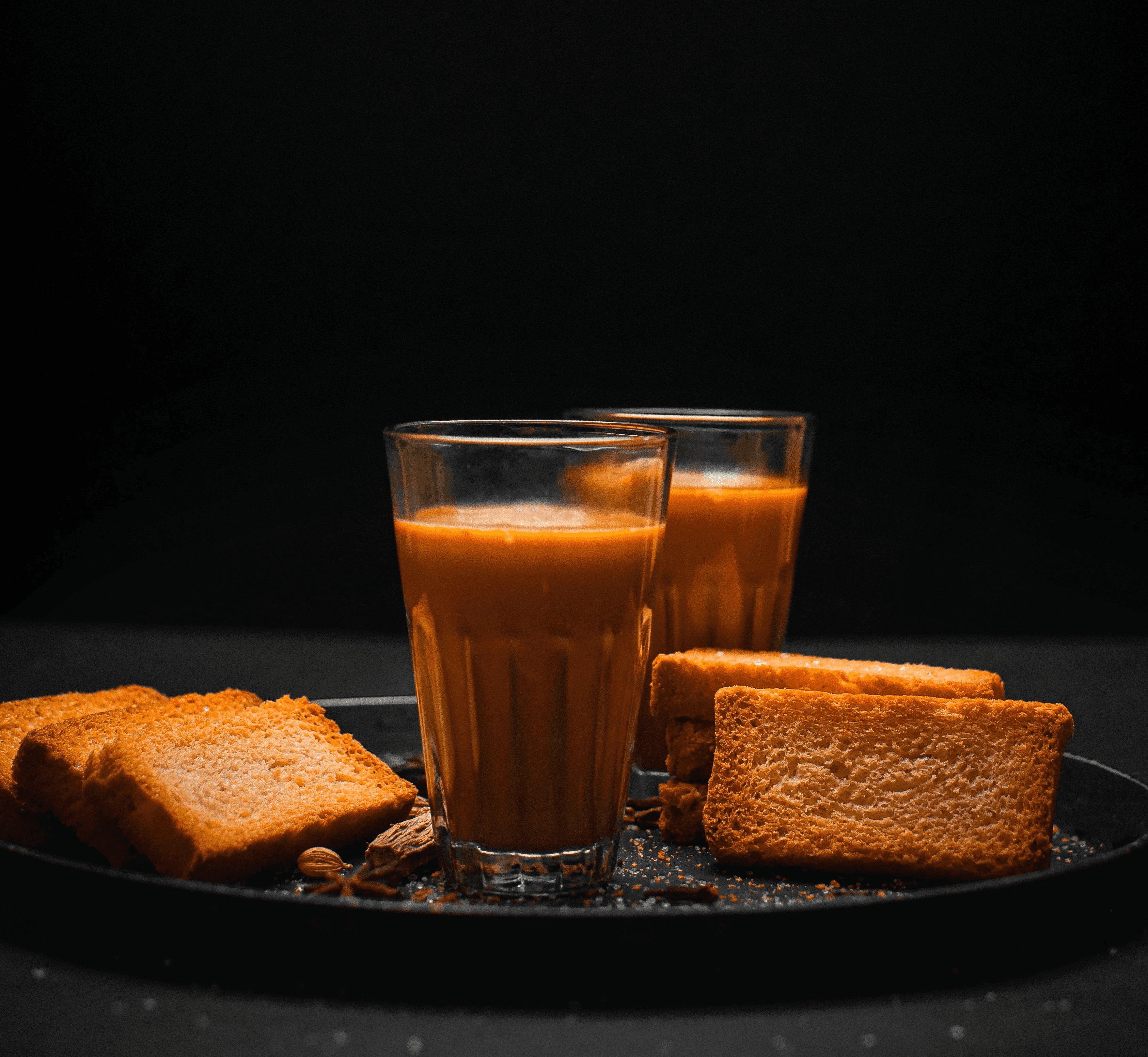 a glass of orange juice and some toast on a plate