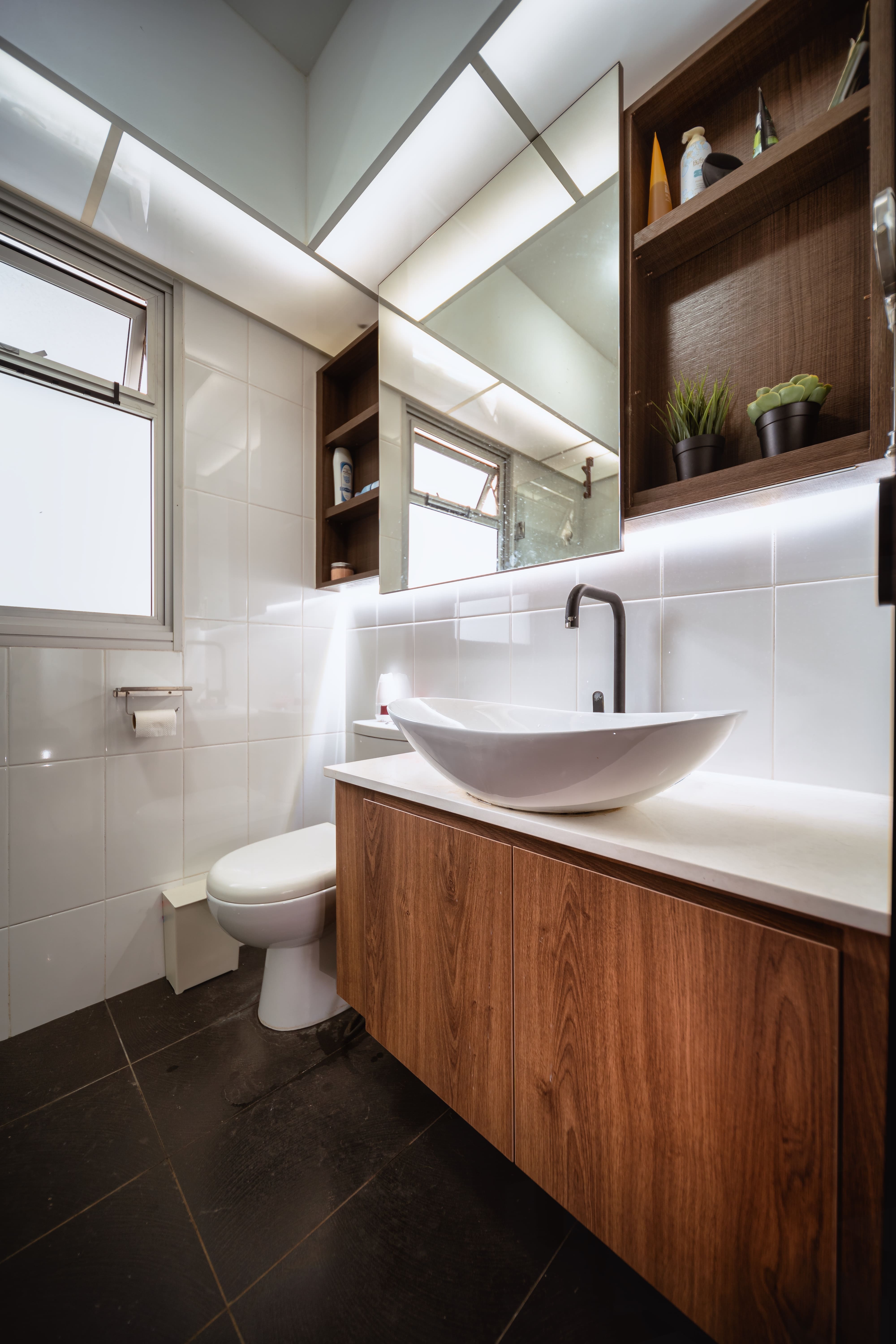 Bathroom design with wood-toned cabinetry, integrated shelving, and soft ceiling lighting for a spa-like effect.