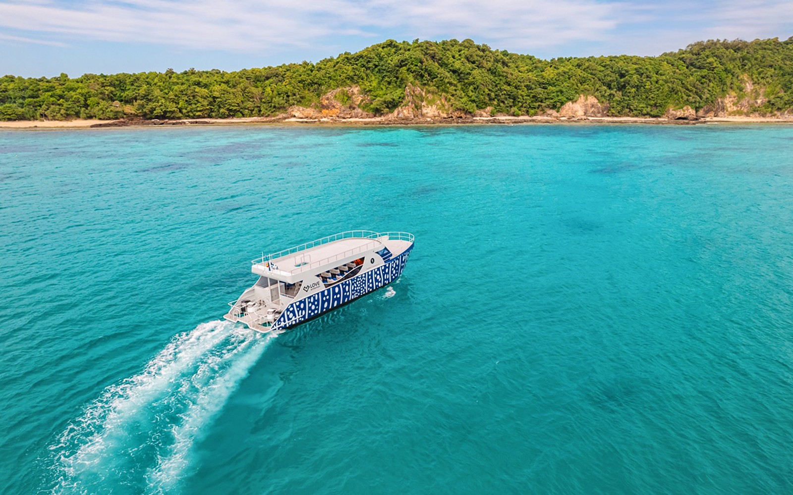 快速艇在郁郁葱葱的绿色岛屿附近的碧蓝海水中巡航。