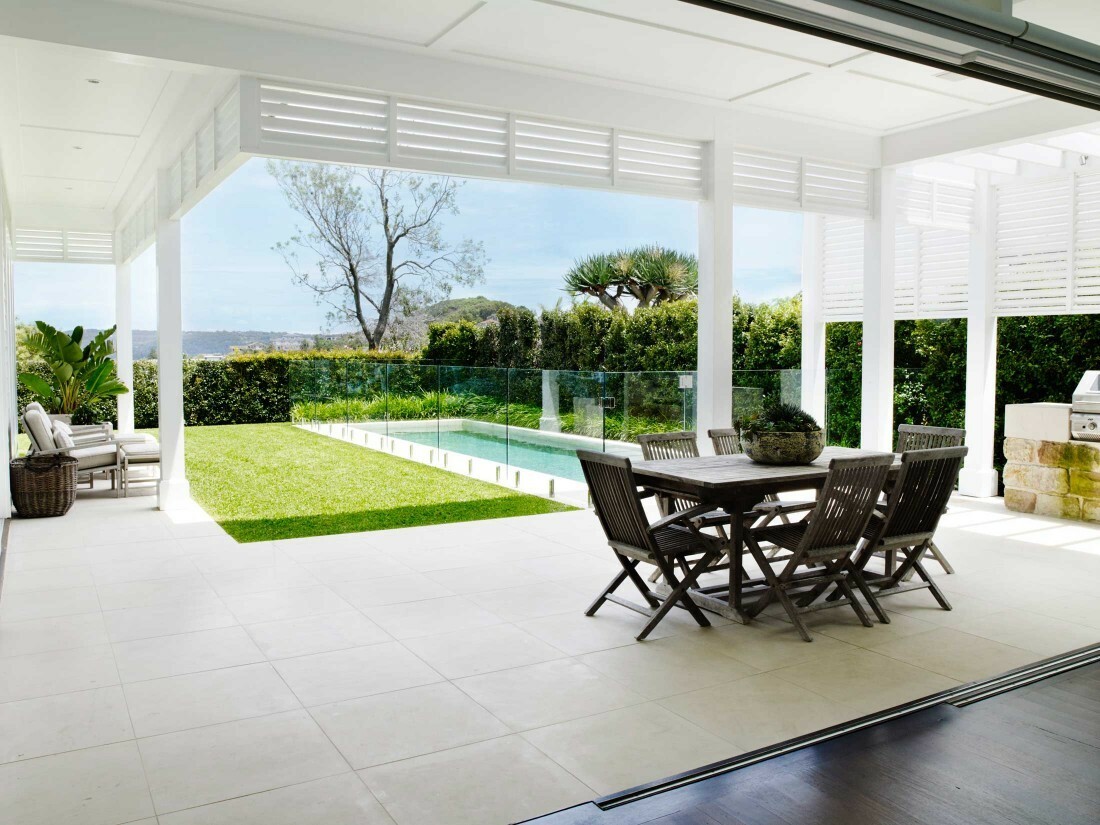 A clean paved outdoor entertaining area beside a garden