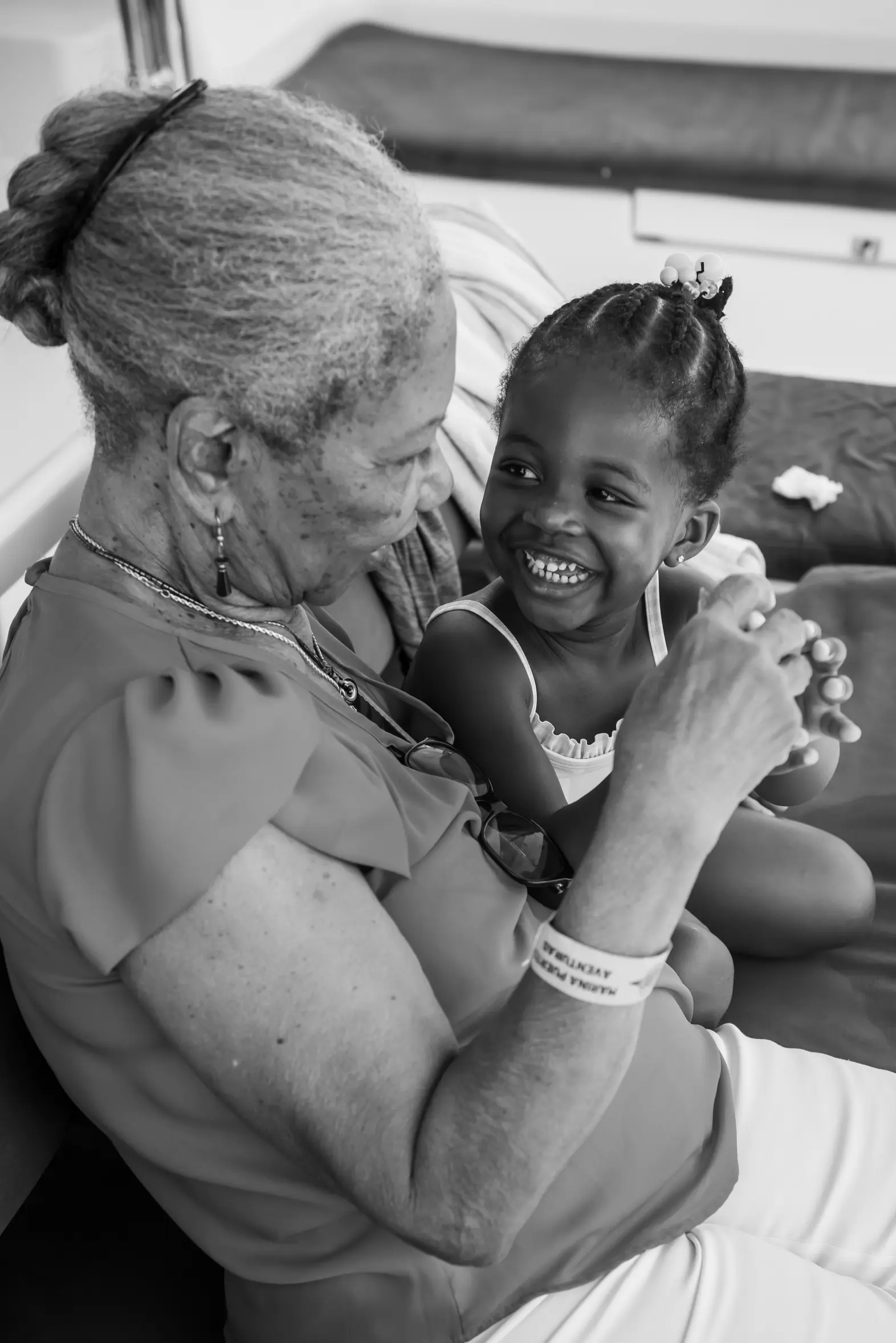 Black and white photo of a grandmother and grandchild holding hands, warm intergenerational moment