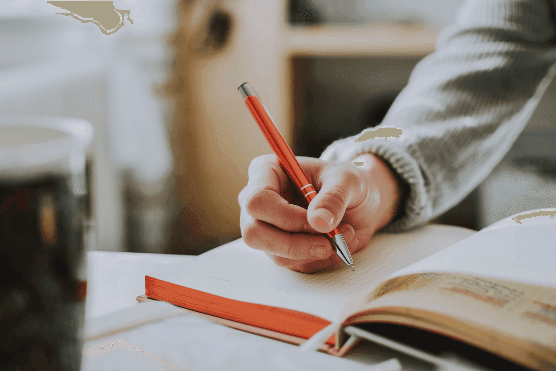 Person writing in a notebook for screen-free planning.