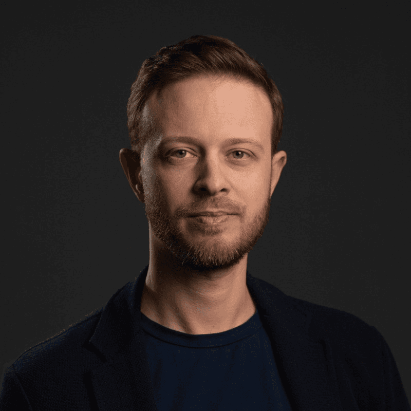 a man with a goatee smiles at the camera