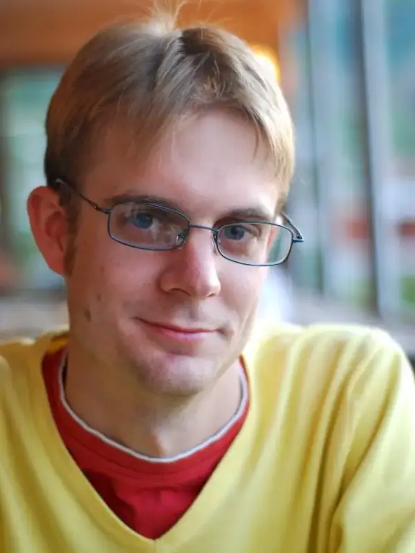 Headshot of author Chris Kempshall in a yellow shirt