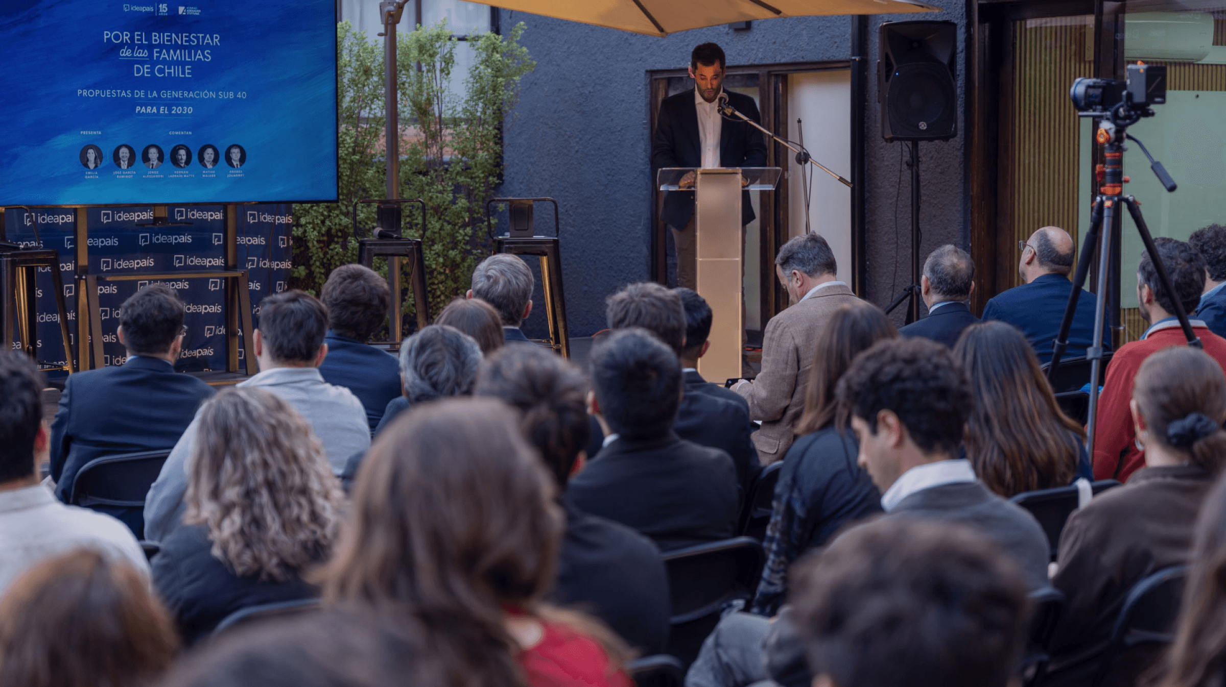 Cristián Stewart, director ejecutivo de IdeaPaís, habla en un podio en el lanzamiento del estudio “Por el bienestar de las familias de Chile: propuestas de la generación sub 40 para el 2030” en el frontis de la oficina de IdeaPaís.