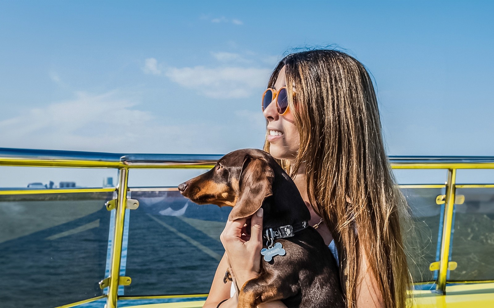 Turista con il suo cane su una crociera in catamarano, godendosi la vista sull'oceano.