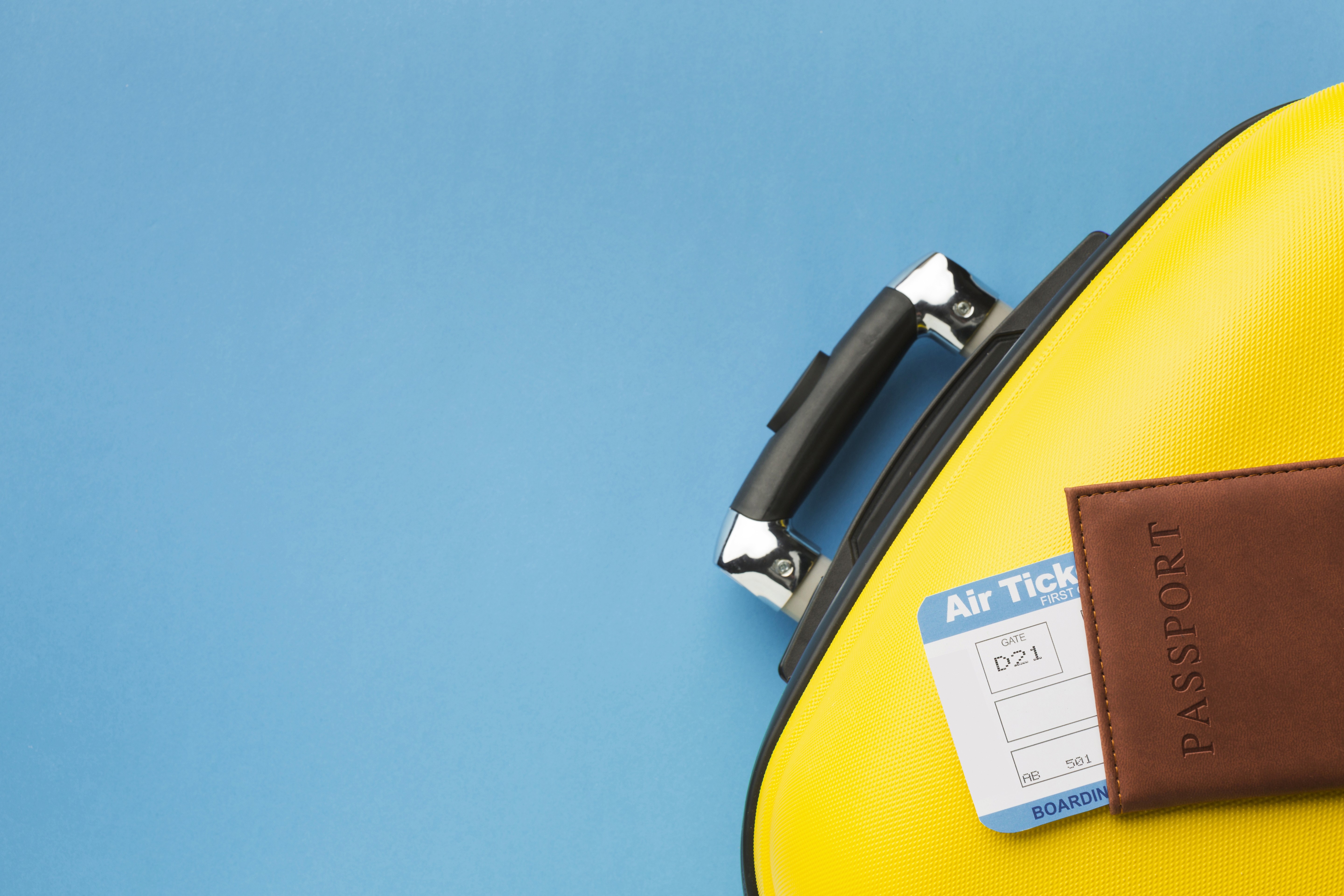 Landscape with a vineyard in rows leading to a building with a tower, rolling hills in the distance.