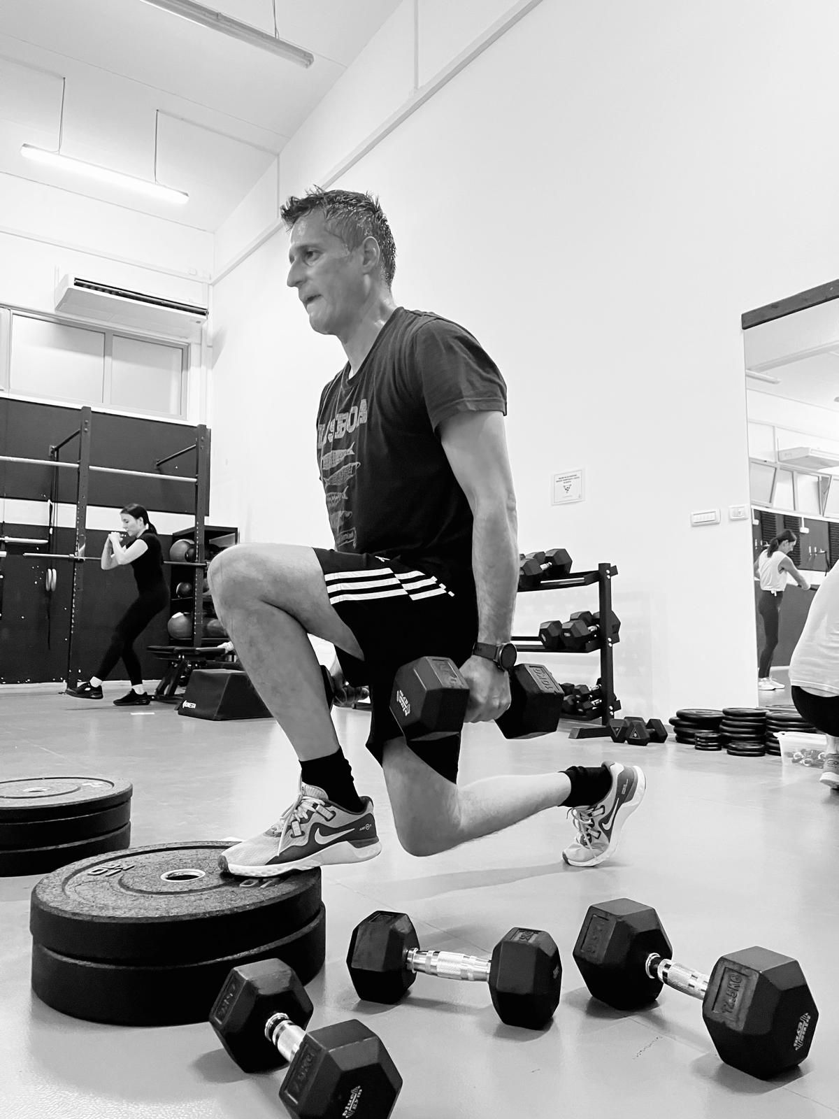 Polaznici grupnog funkcionalnog treninga s girjama u svijetloj fitness dvorani.