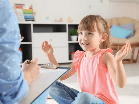 a smiling young girl gesturing something to an adult