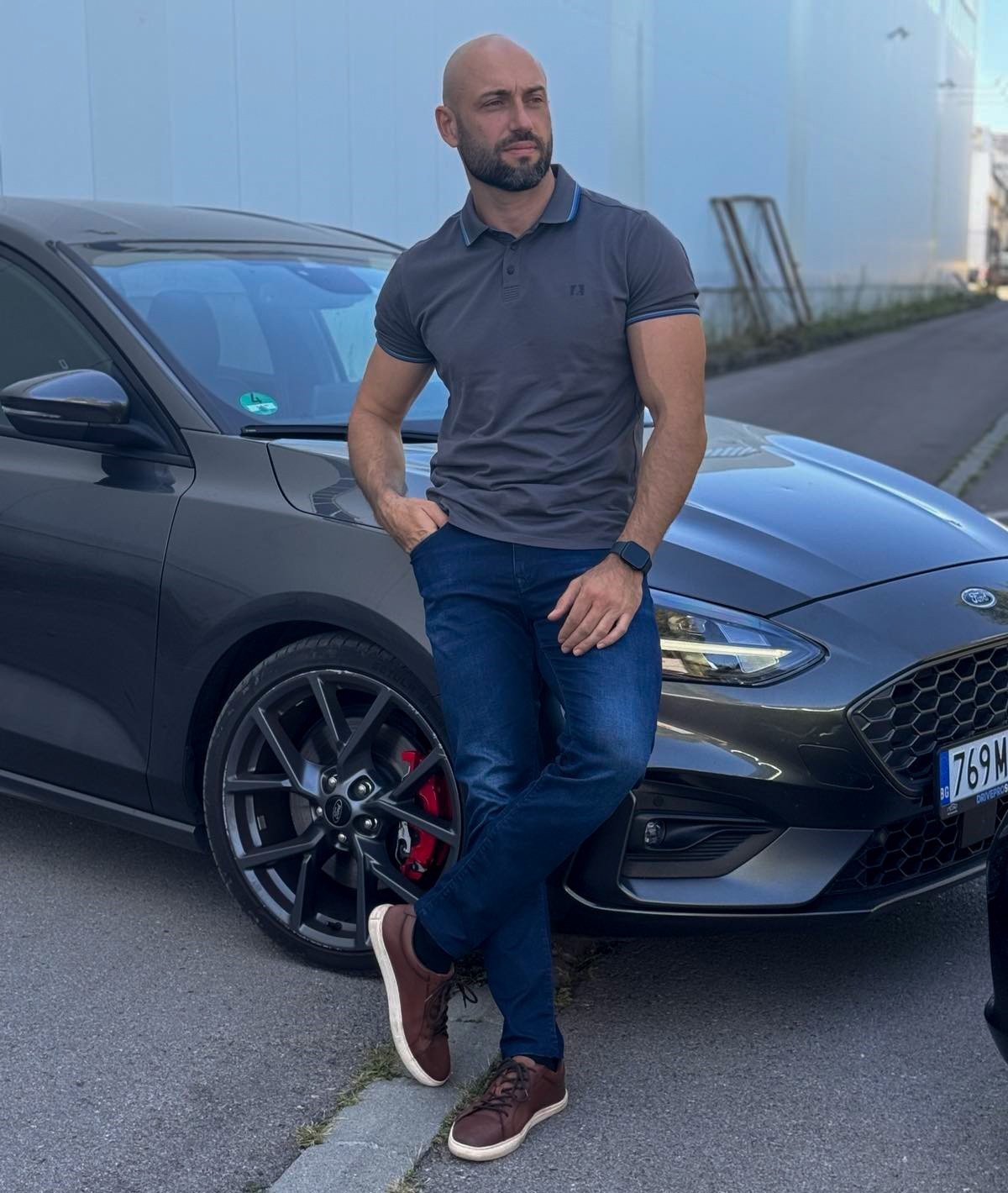 a car salesman standing next to his car