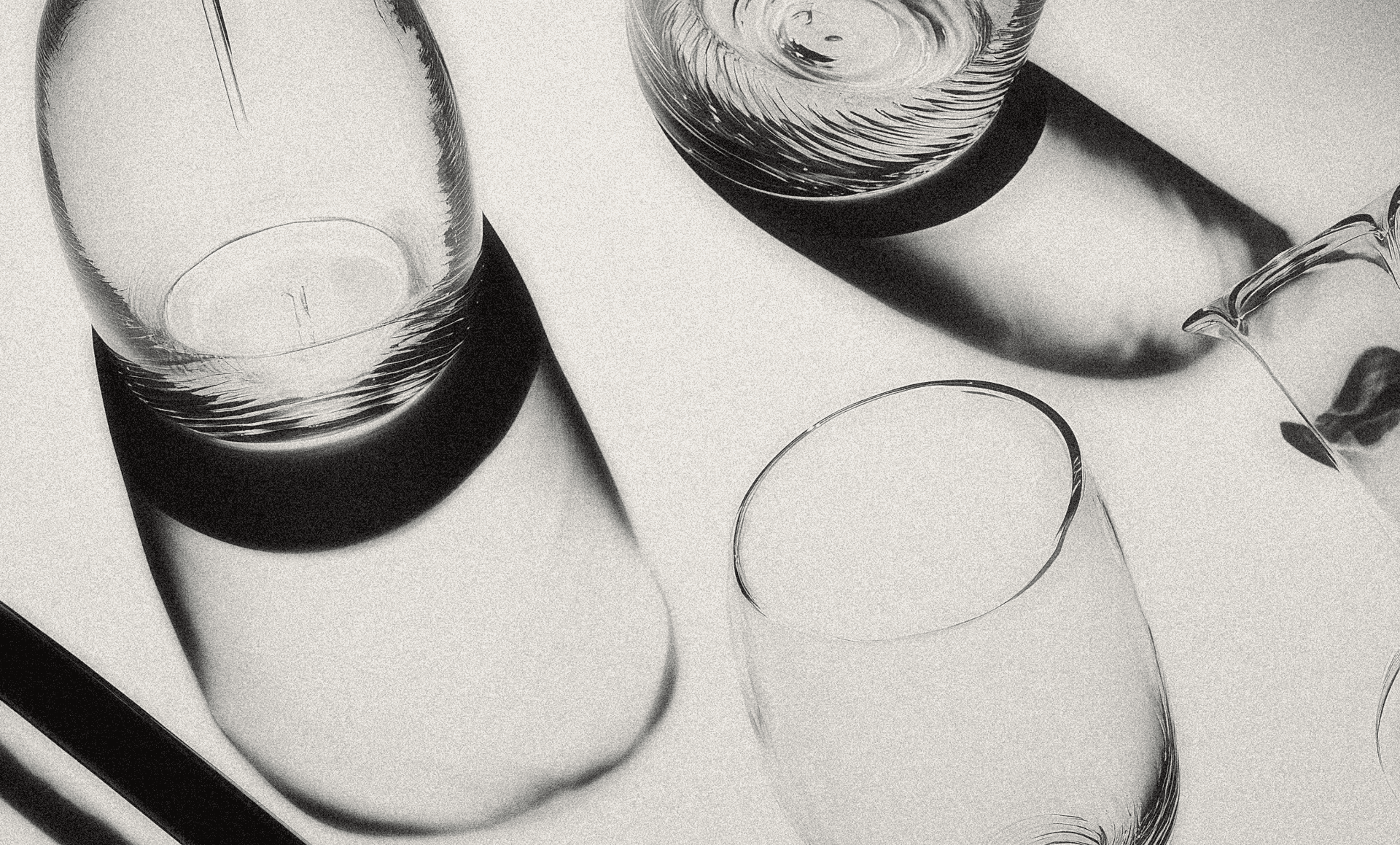 Minimal glassware arrangement shot from above with sharp shadows