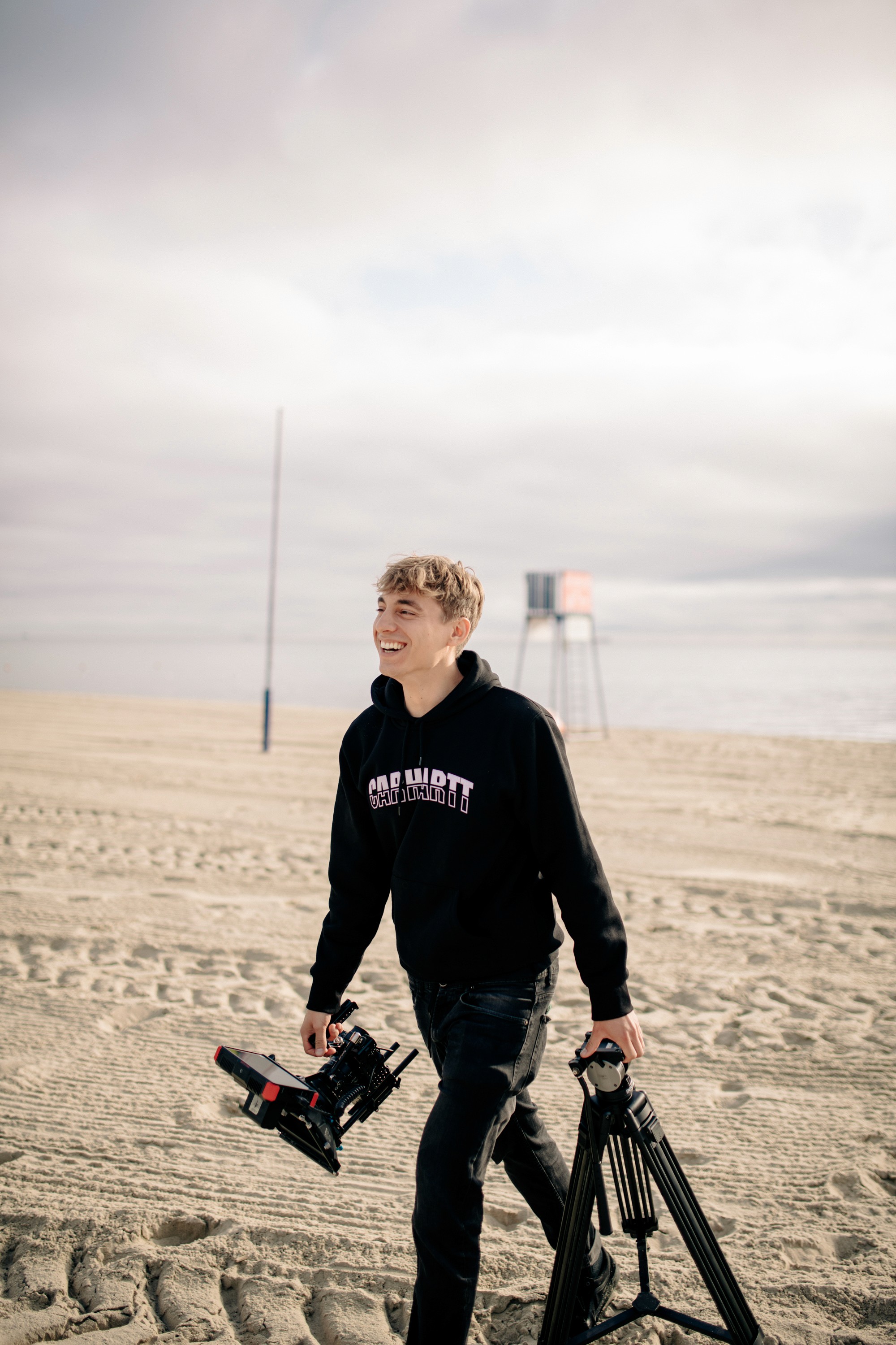 A thoughtful young person with dark hair gazes to the side, captured in soft black and white lighting.
