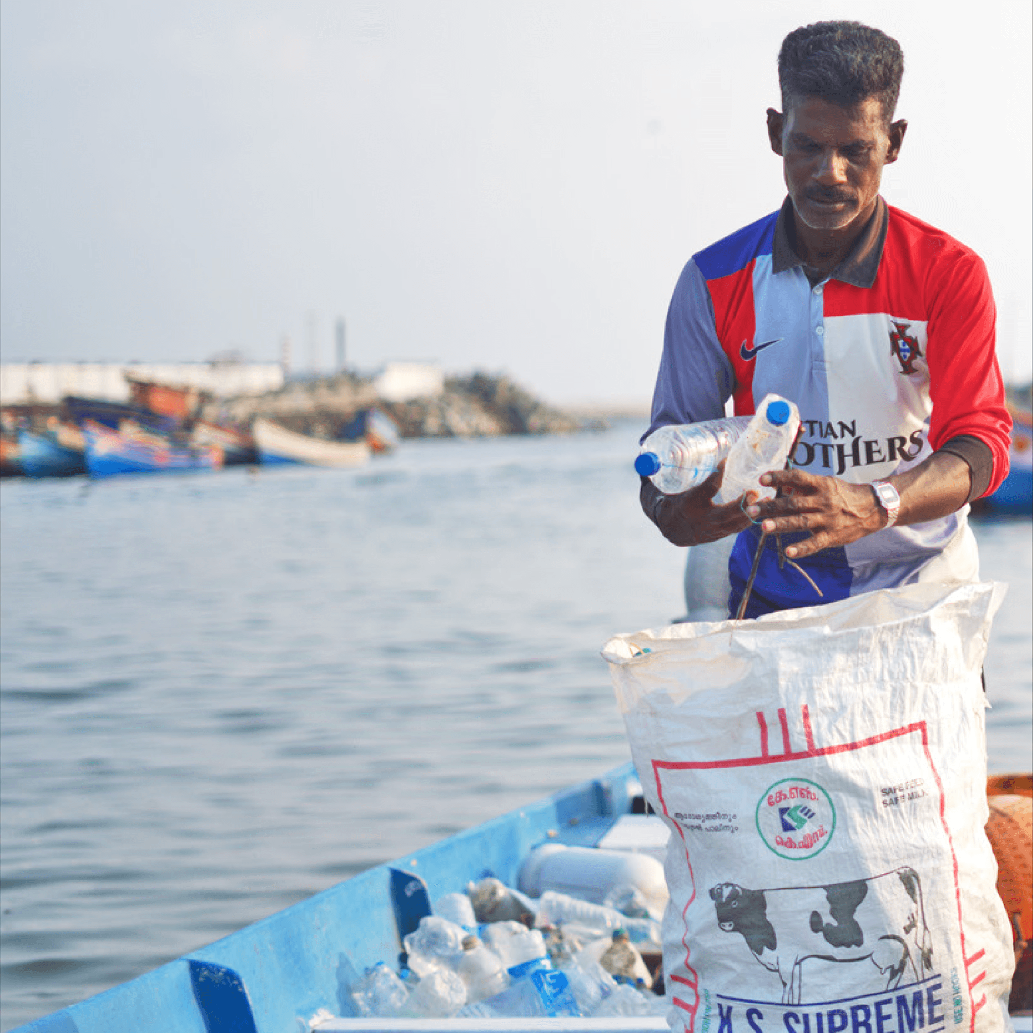 Woman in red outfit poses by a red telephone booth.