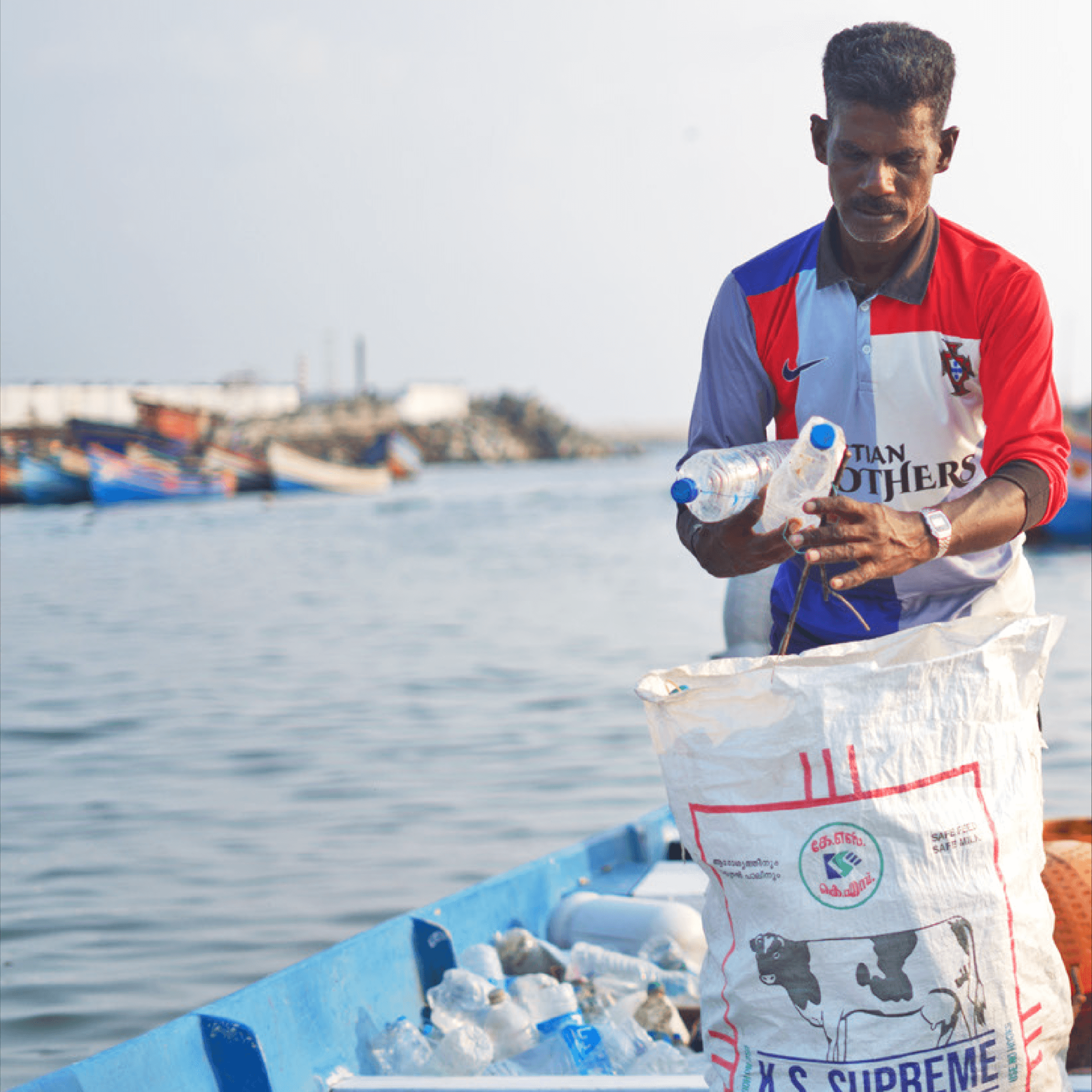 Woman in red outfit poses by a red telephone booth.
