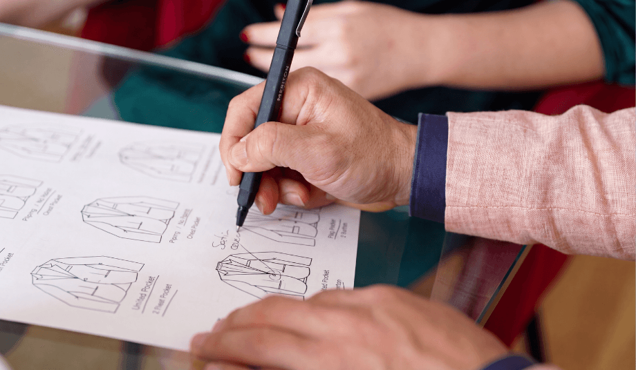 Custom suit consultation appointment showing jacket design sketches and tailored options being marked