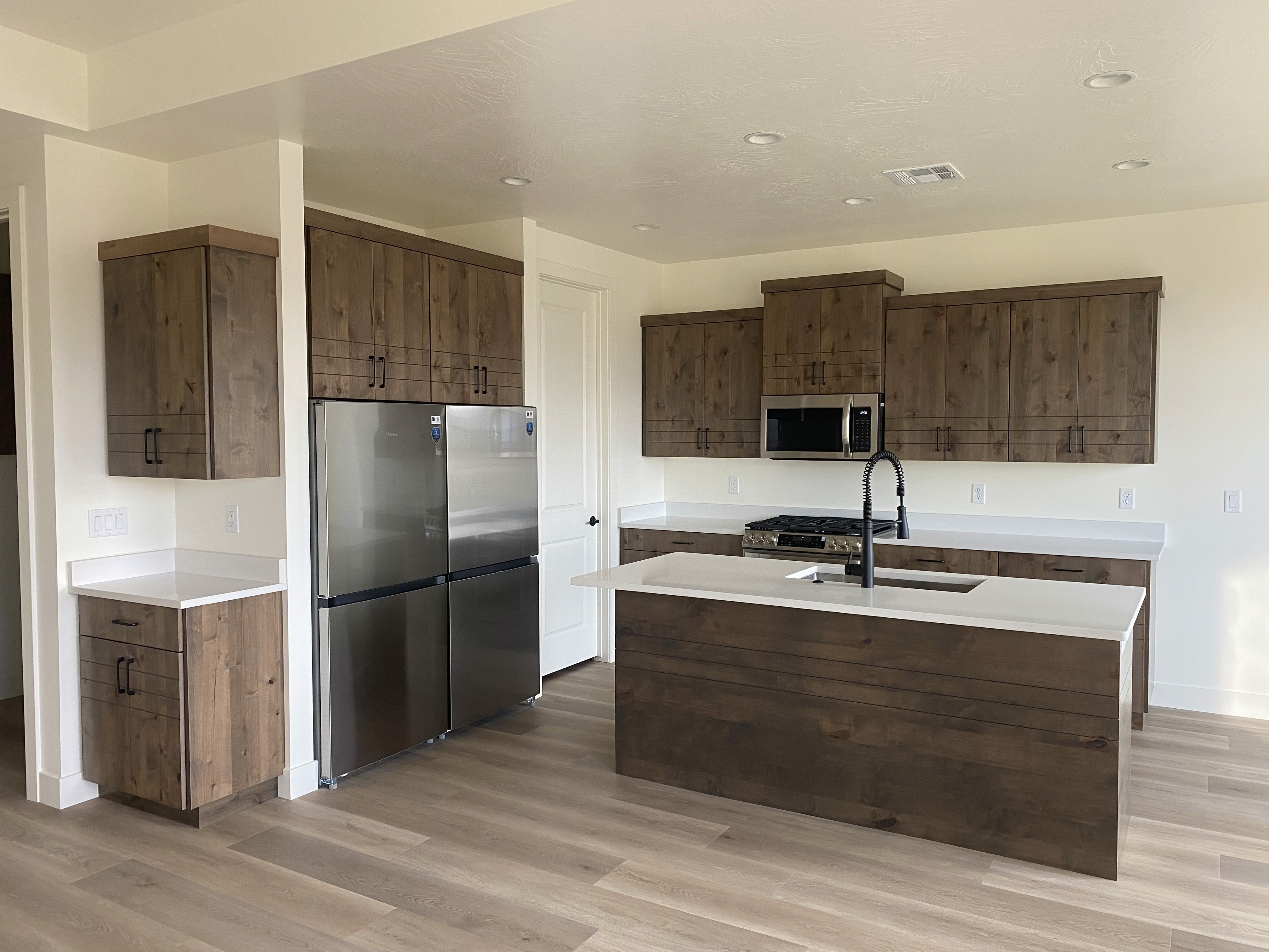 Kitchen inside the Golden Hour home in Hurricane, Utah featuring modern cabinetry and a spacious island.