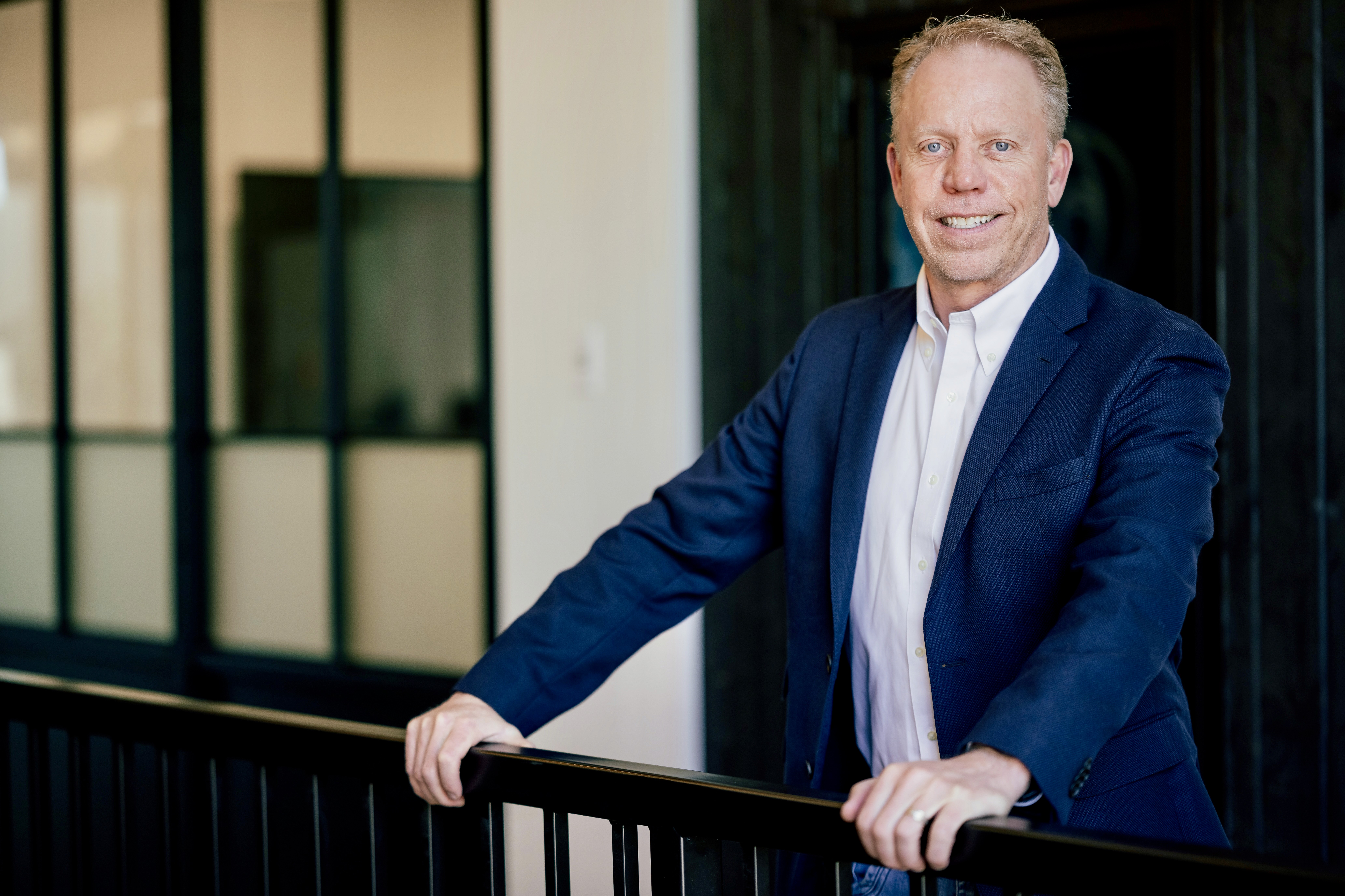woman in blue tank top standing beside white wall