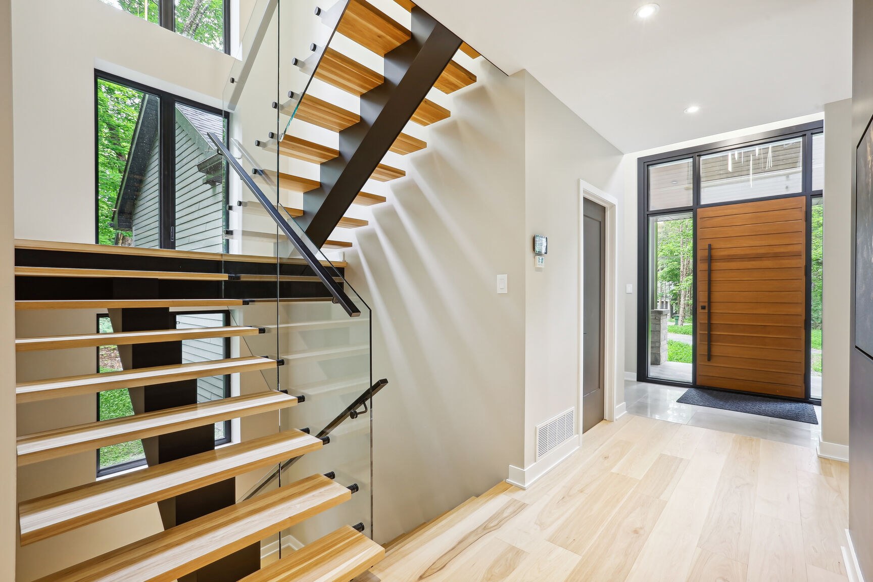 Escalier architectural acier/bois avec garde-corps en verre.